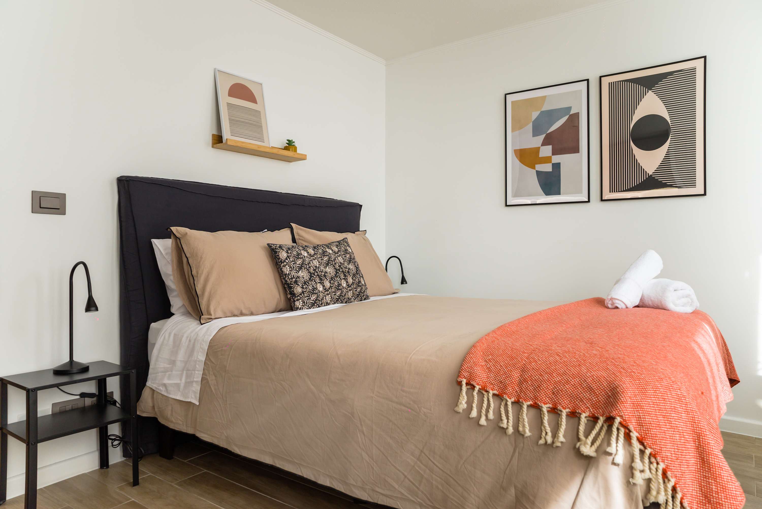 Cozy and stylish studio bedroom with modern decor and inviting bedding, perfect for a relaxing stay.