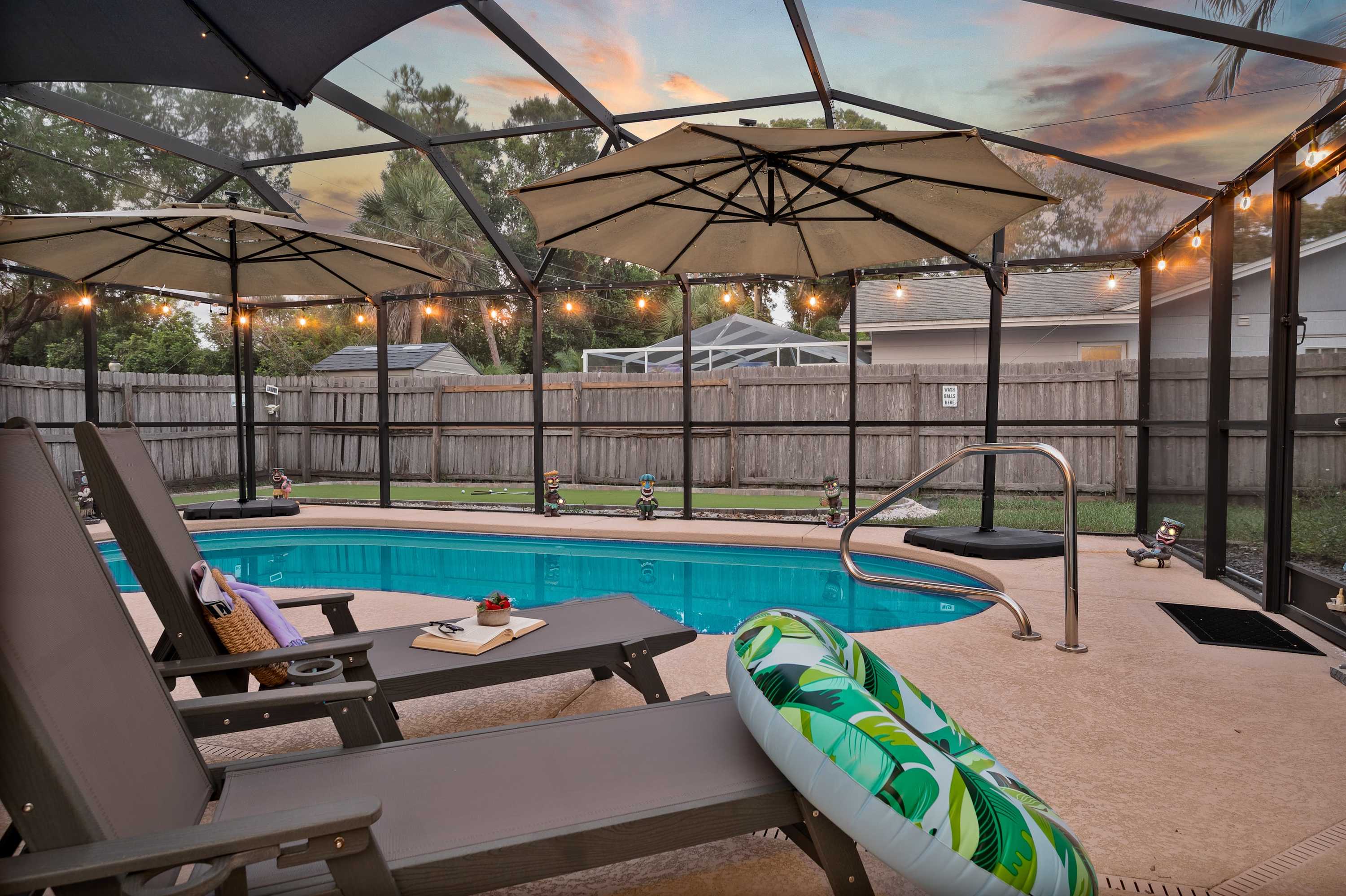 Spend your evenings in your private outdoor oasis! This screened-in patio features comfortable seating, a large umbrella for shade, and charming string lights that create the perfect ambiance for relaxing by the pool after a day of fun.