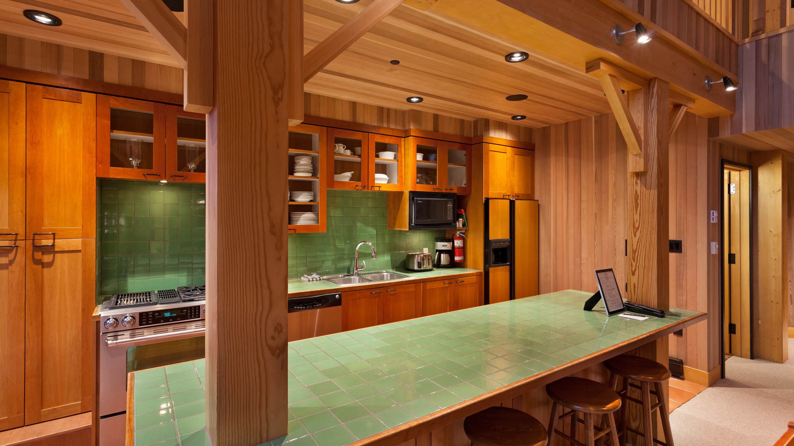 - Fully equipped kitchen with green tile backsplash and premium appliances 
- Long breakfast bar ideal for morning coffee before hitting the slopes 
- Wooden interiors blend warmth and functionality in a true alpine style 