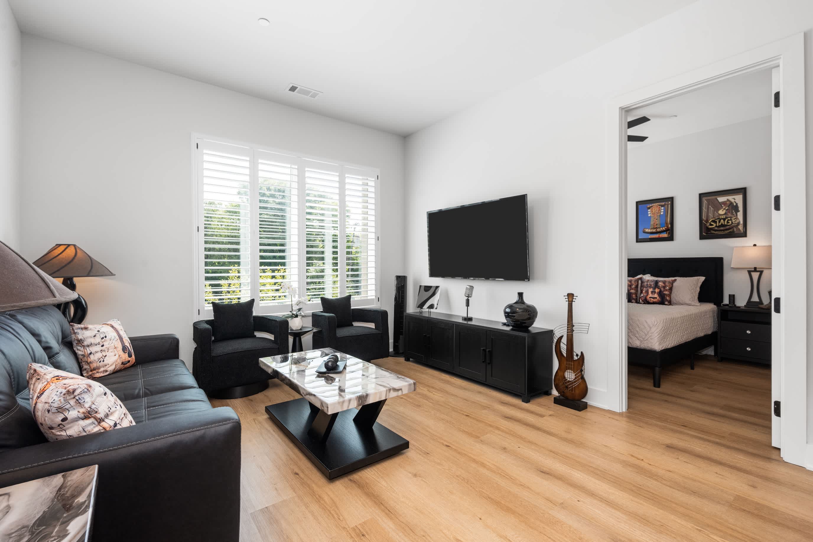 Light-filled living space with leather sofa bed and comfy armchairs—perfect for lounging after a day out.