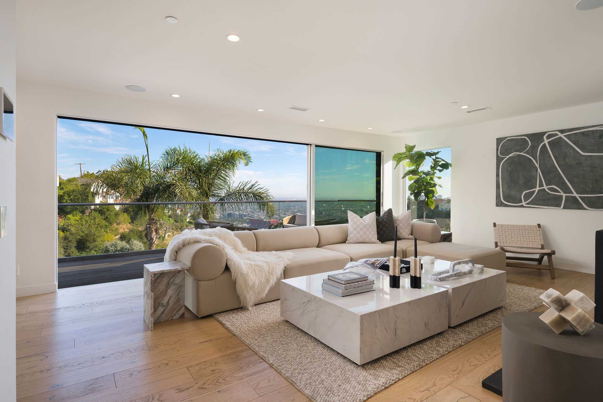 1st floor living room lounge with floor to ceiling glass windows, balcony with seating, smart TV and fireplace.