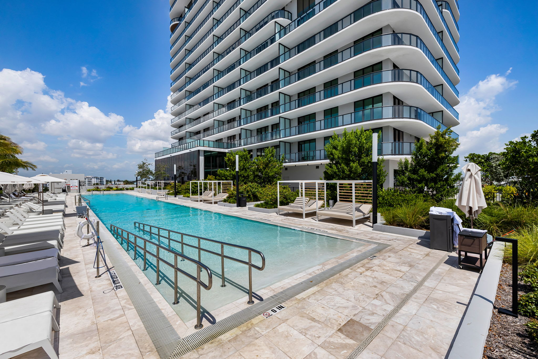 Enjoy a refreshing swim in this stunning pool with a modern high-rise backdrop, perfect for relaxation and leisure.