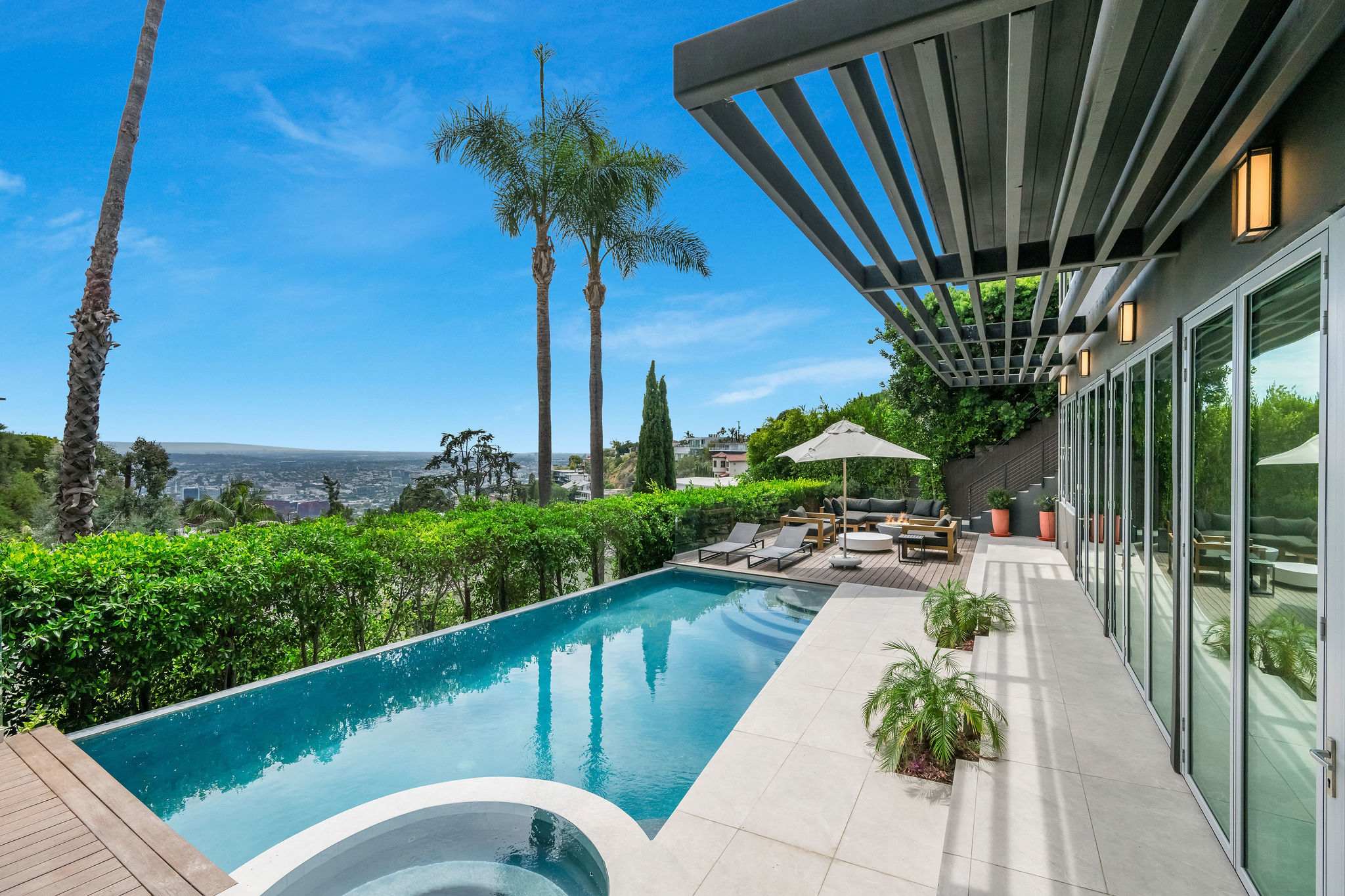 Outdoor area with pool, outdoor seating, indoor-outdoor fun room connecting the pool to the inside of the home