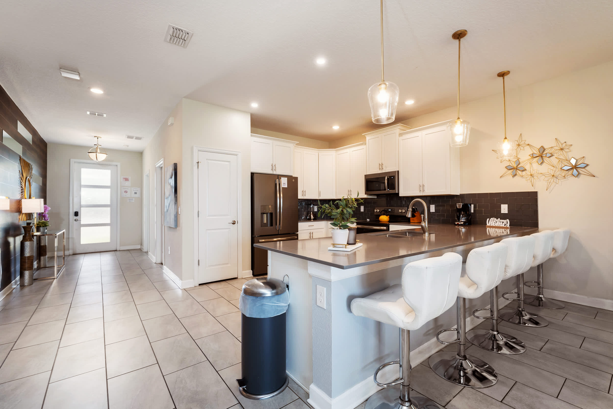 Spacious private kitchen with a generous island, four bar stools, stainless-steel appliances, and a charcoal subway-tile backsplash for easy group meals.