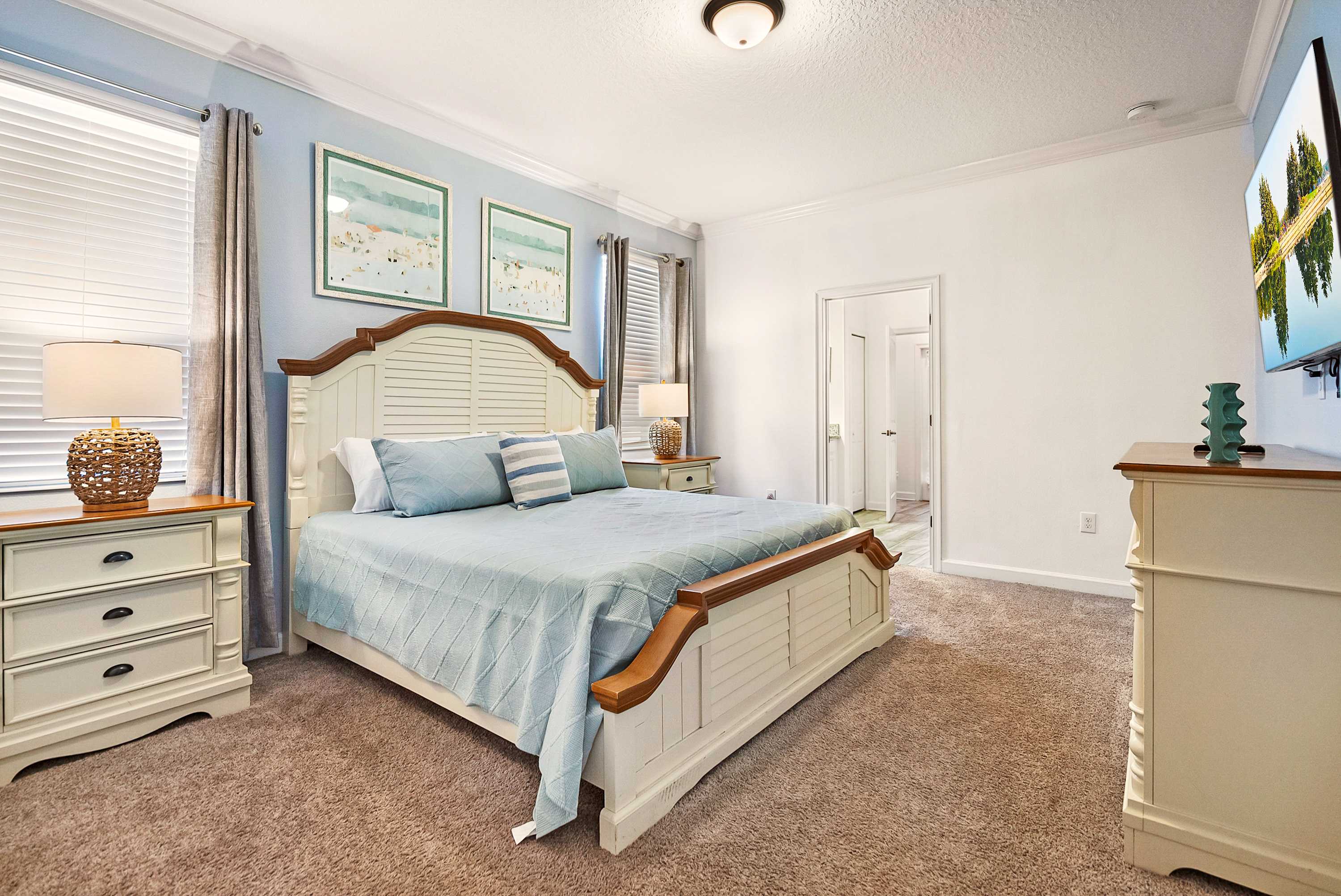 Relax in this serene bedroom featuring plush bedding, elegant decor, and a convenient ensuite bathroom.