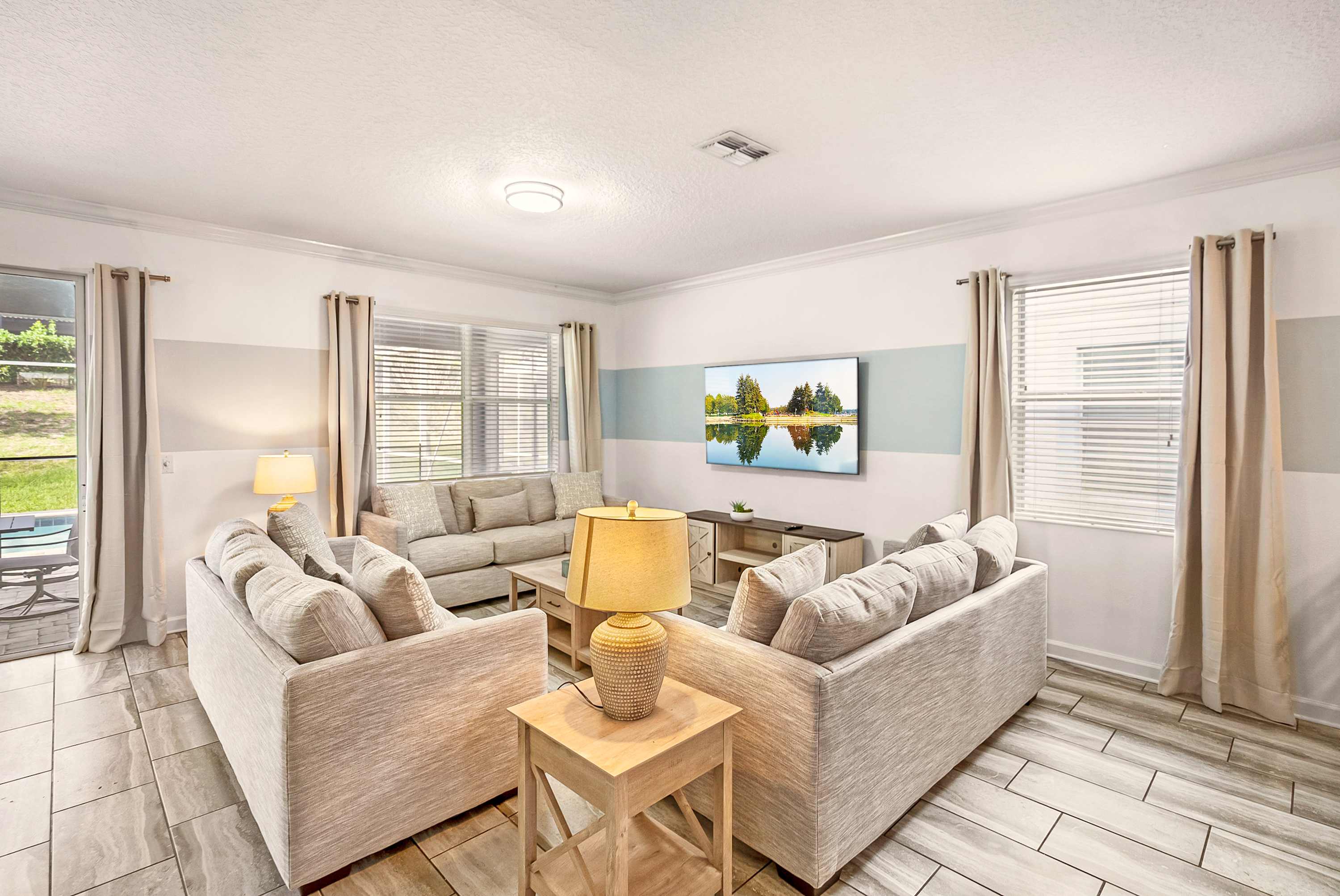 Relax in the spacious living room with plush seating and a large TV, ideal for unwinding after a day of adventure.