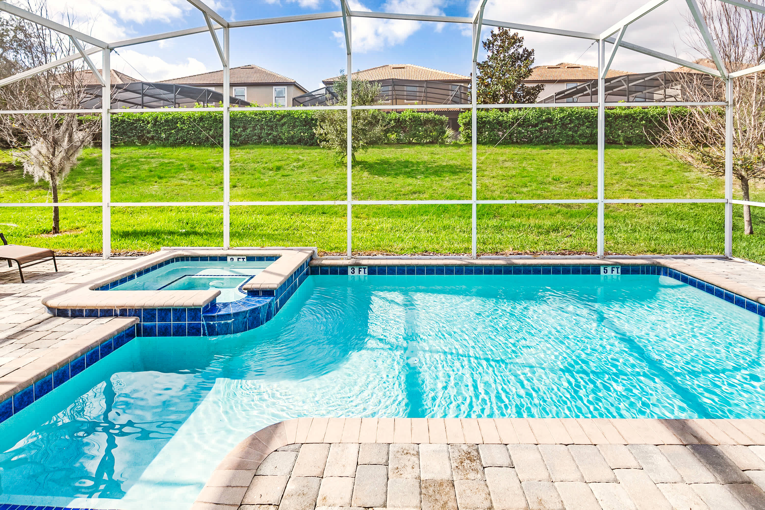 Dive into relaxation with your private pool and hot tub, perfect for unwinding under the sun amidst lush greenery.