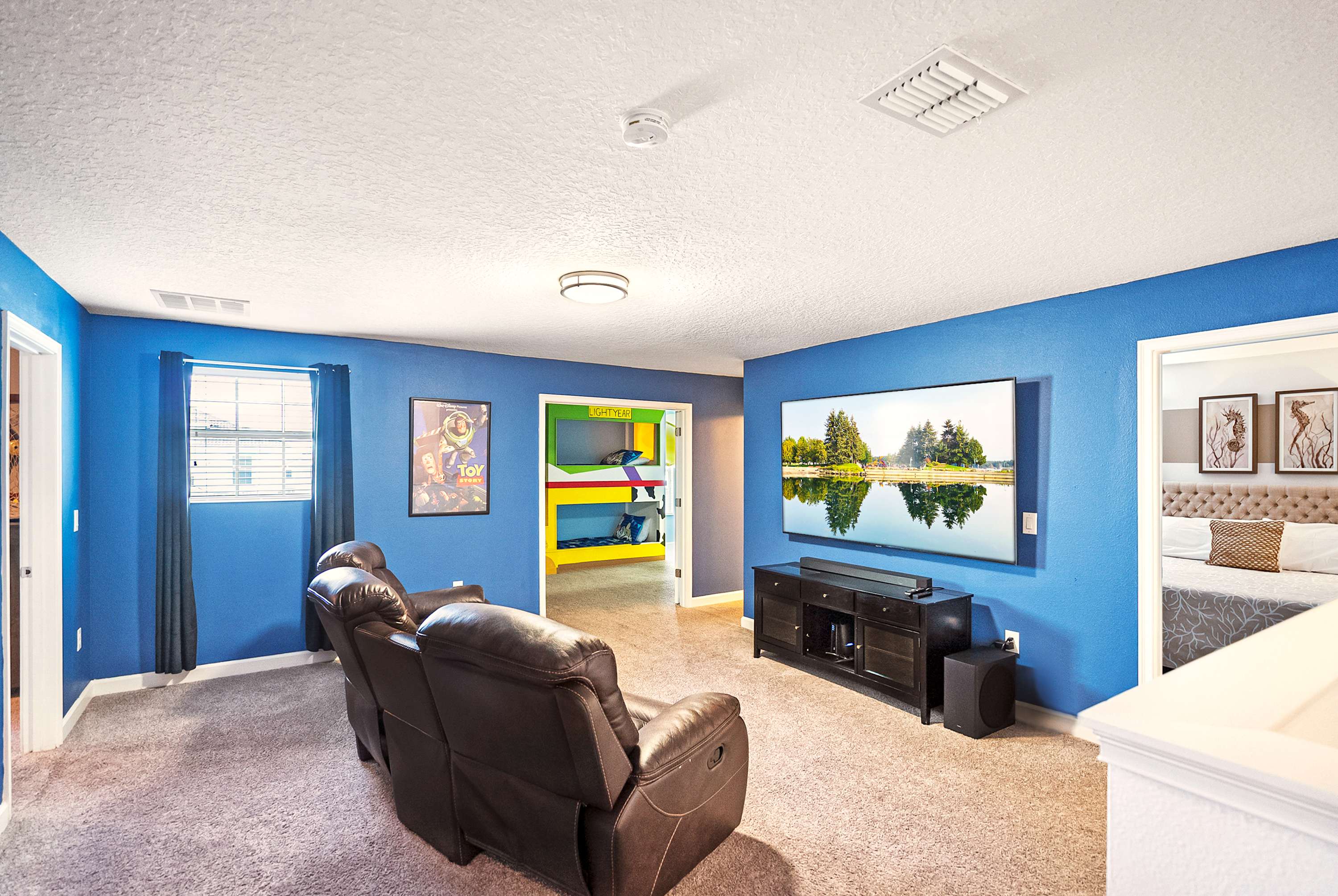 Enjoy family fun in the vibrant game room with a large TV, cozy recliners, and a playful bunk bed for an unforgettable stay.