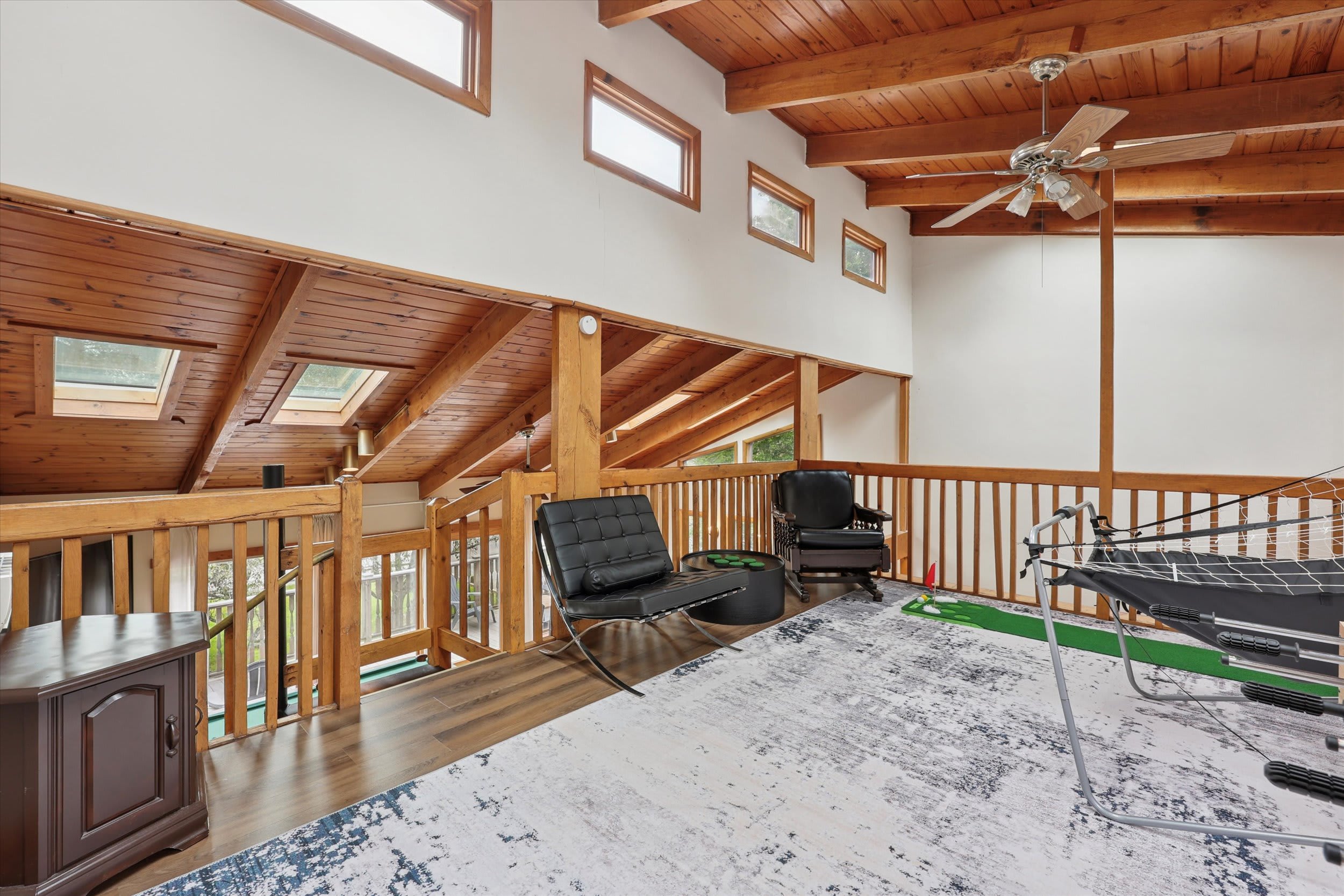 Relax in the spacious loft with soaring wood beams, skylights, and views of the living area below.