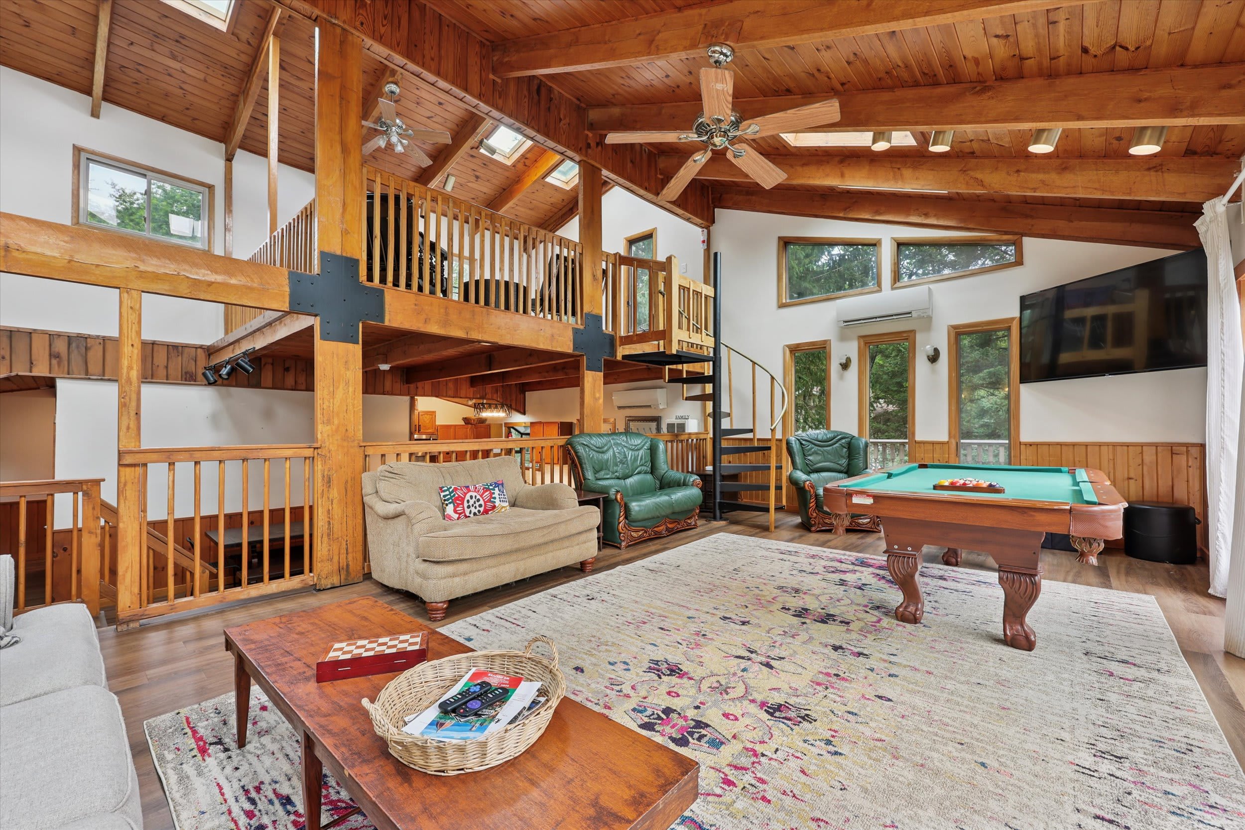 The open living area flows into a loft balcony, perfect for reading or watching the fun below.