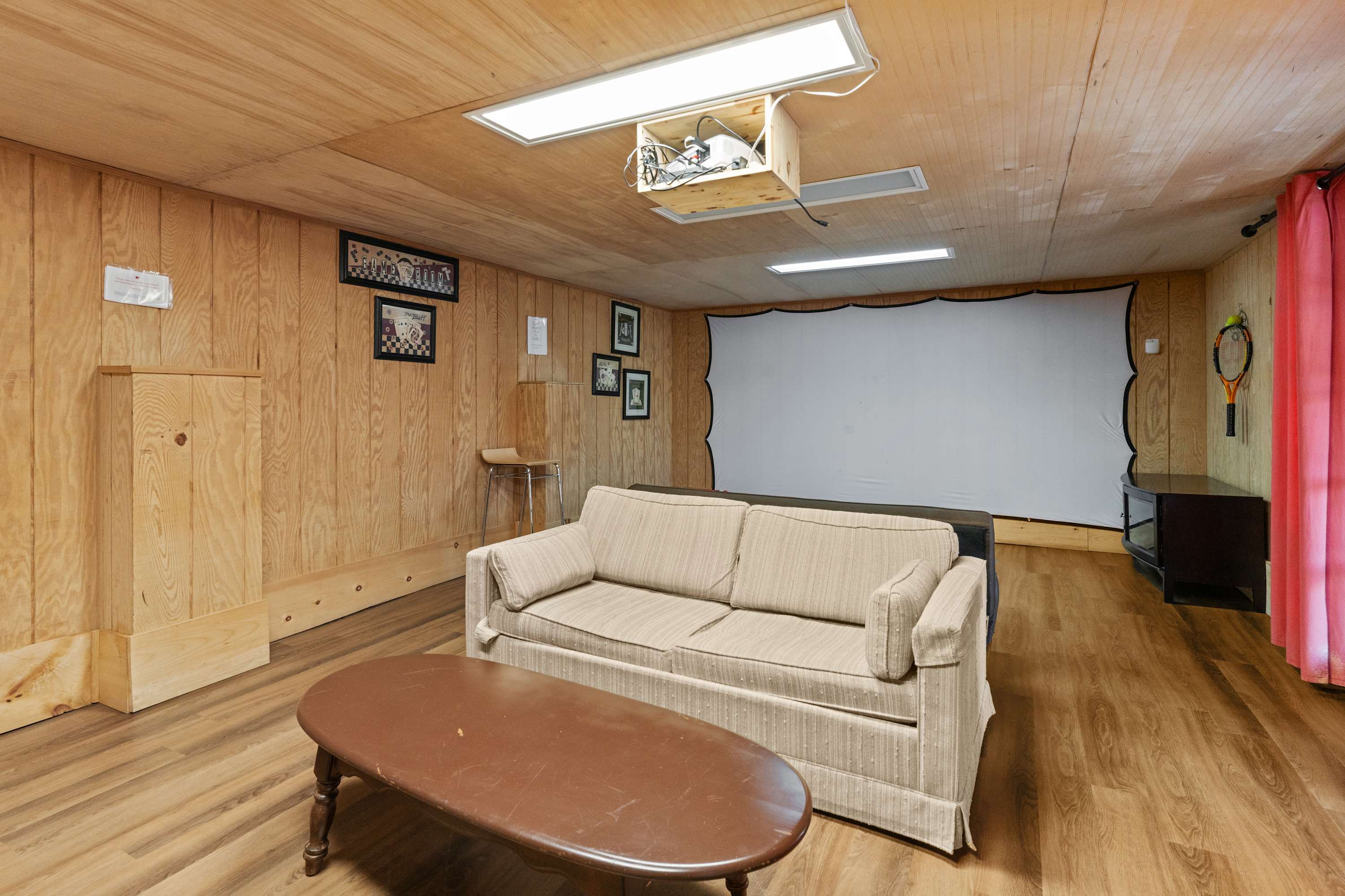 Settle in for movie night with a big-screen projector, comfy sofa, and natural light from skylights.