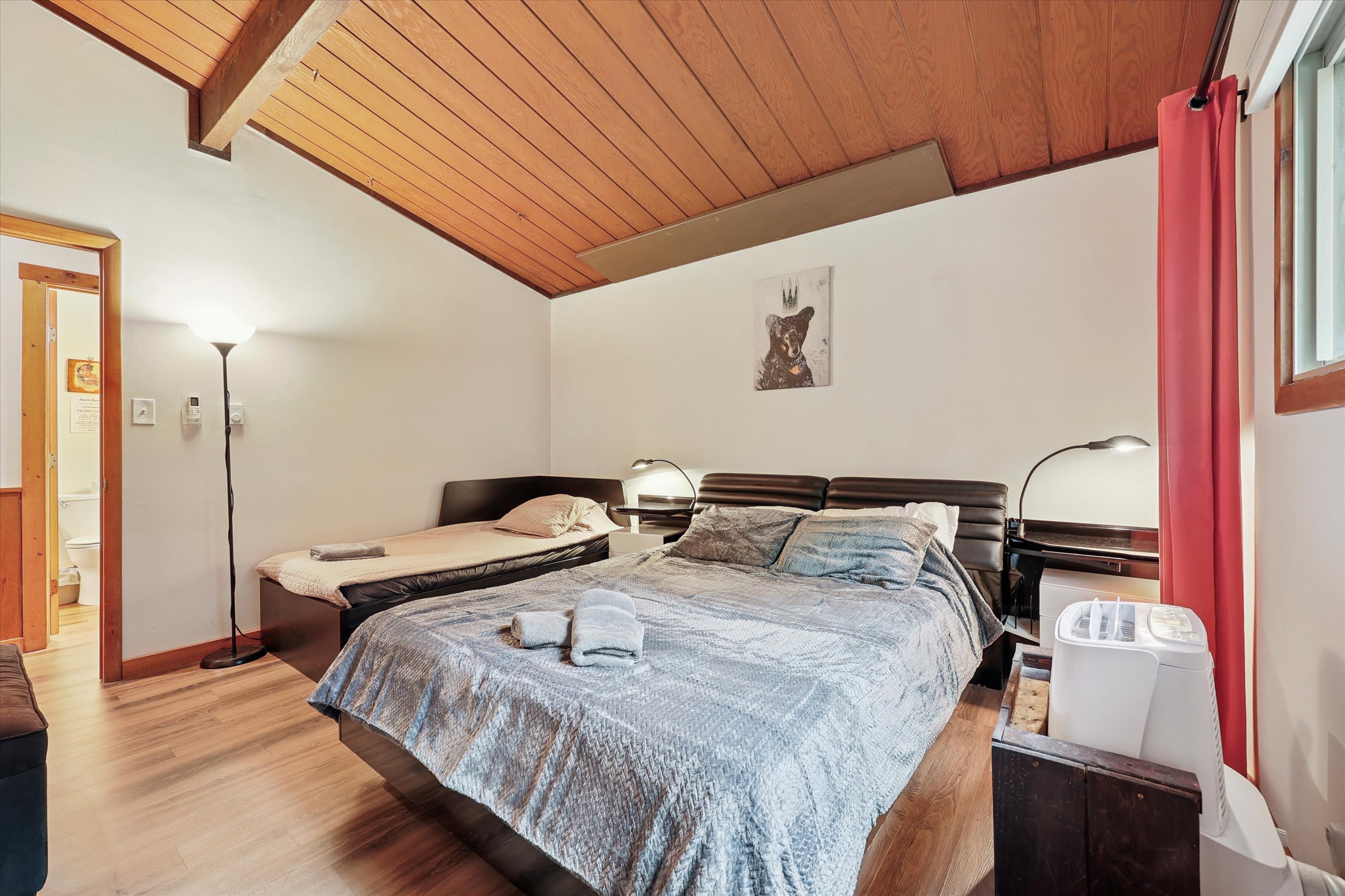 Rest easy in this bedroom with a king bed, vaulted wood ceiling, and a daybed for extra sleeping.