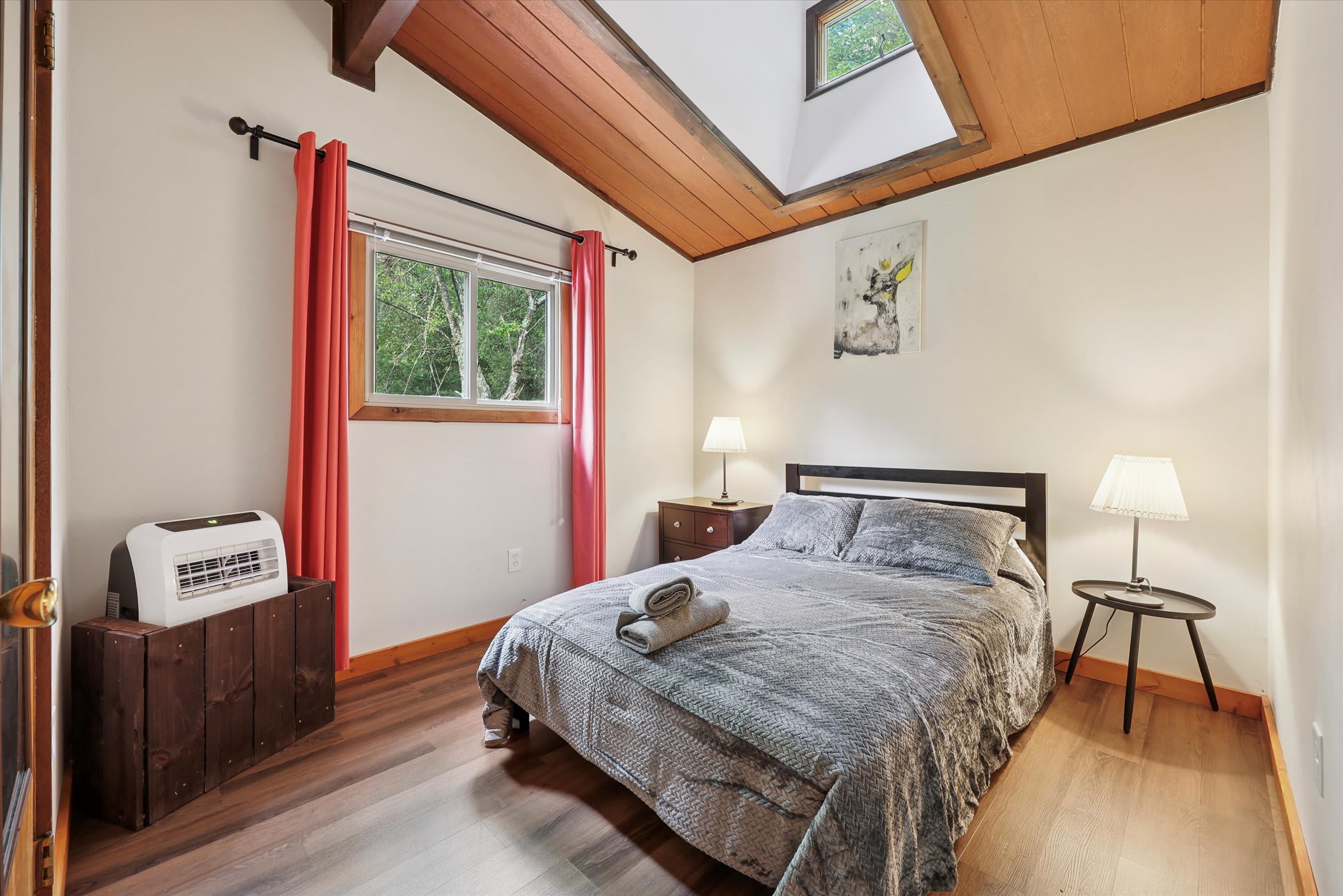 Wake up to natural light through the skylight in this cozy bedroom with a bed.