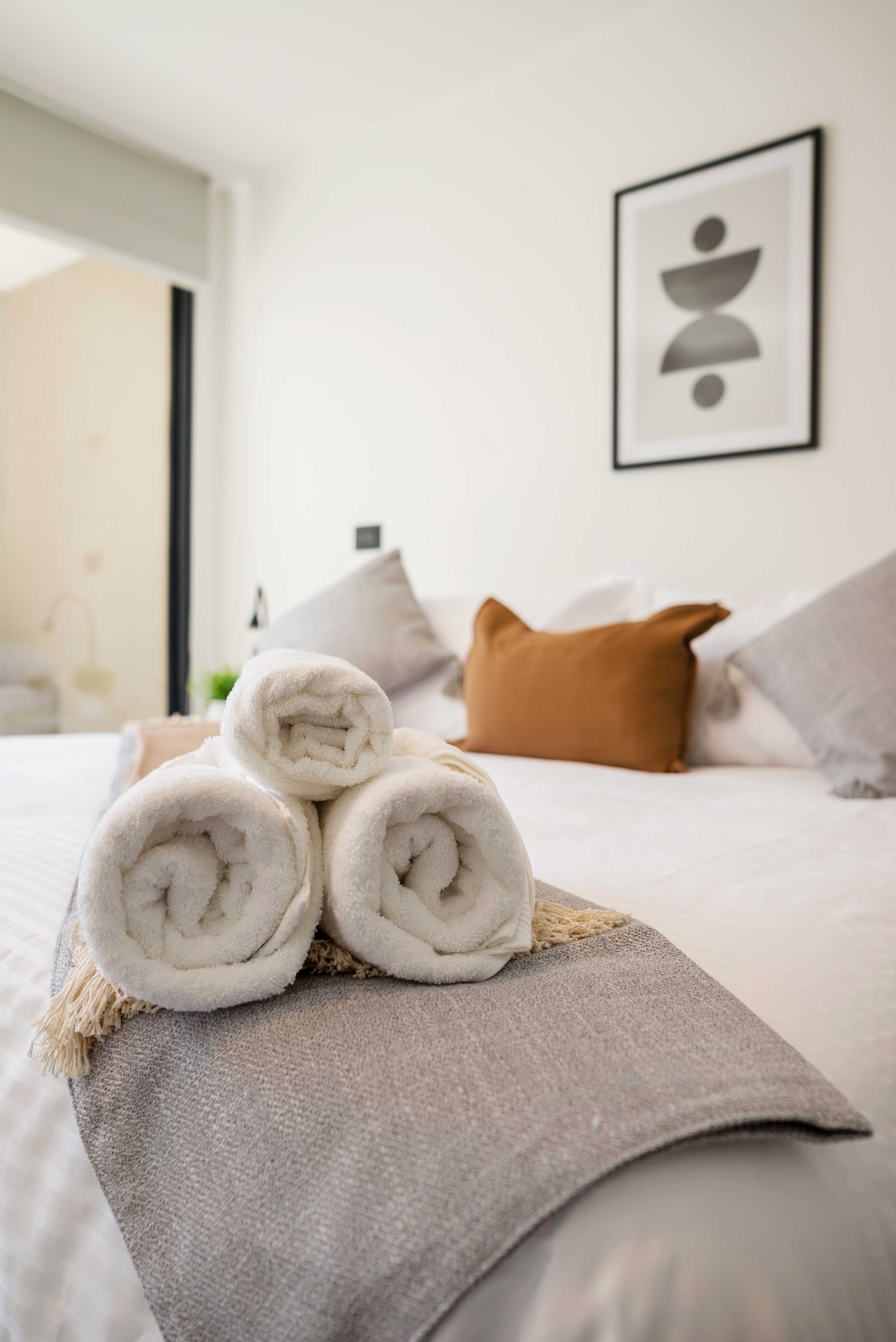 Relax in this cozy bedroom with plush linens and modern decor, perfect for unwinding after a day of exploring.