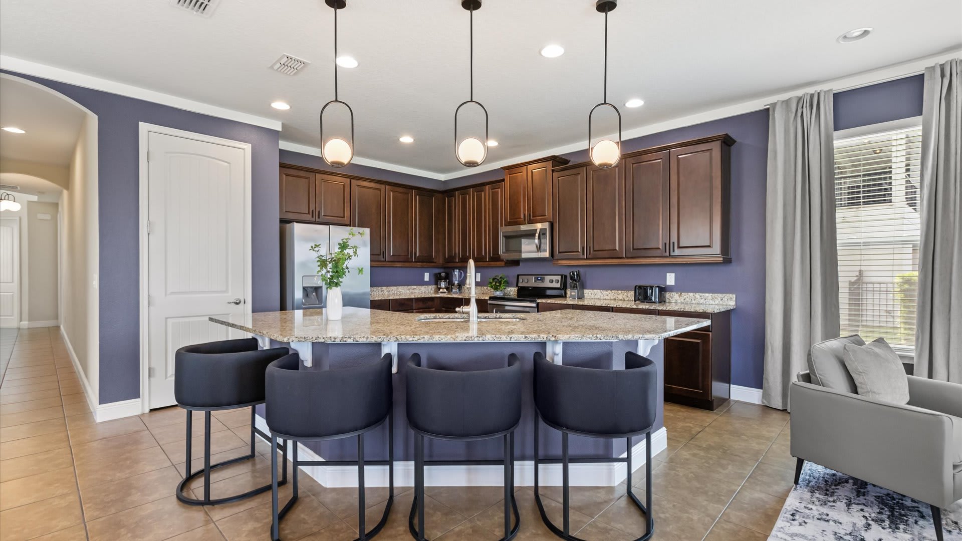 Kitchen area with centred island and bar stools