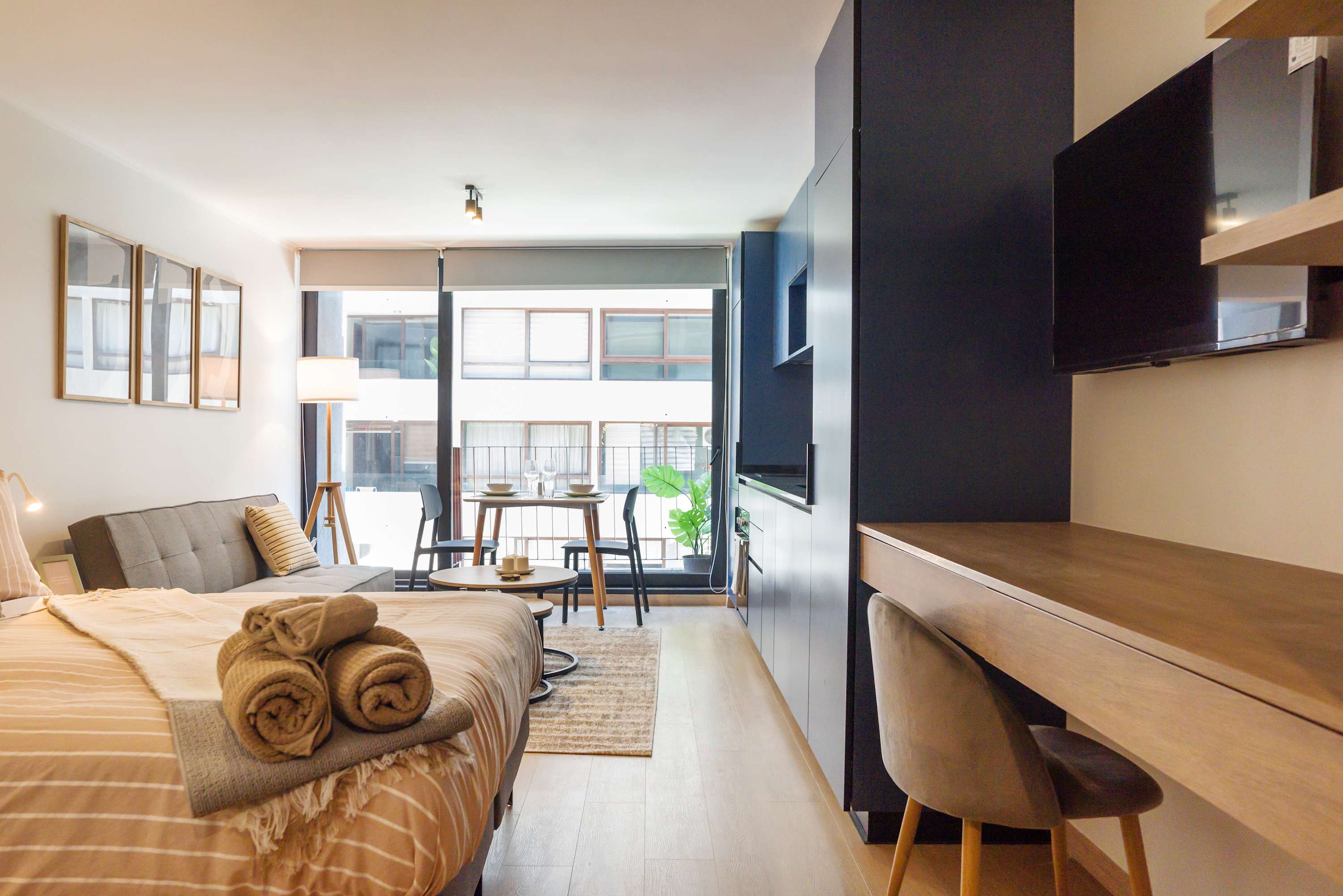 Relax in this chic studio with a cozy bed, stylish workspace, and ample natural light, perfect for a comfortable stay.