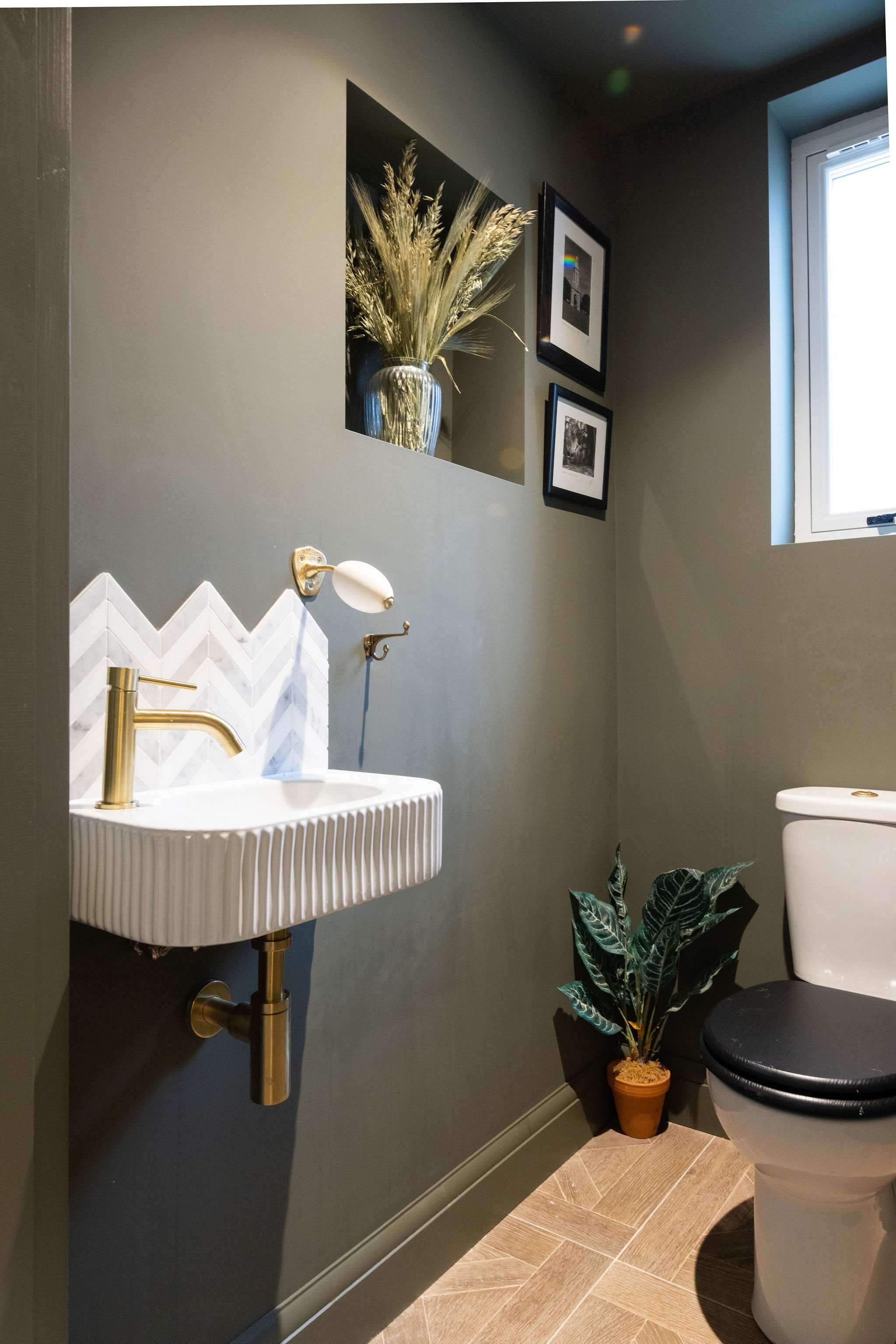 A stylish downstairs cloakroom with bold design and elegant brass details.