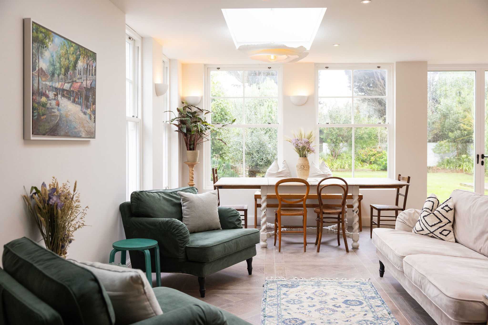 Sunlit living and dining with comfy seating and beautiful views of the private garden.