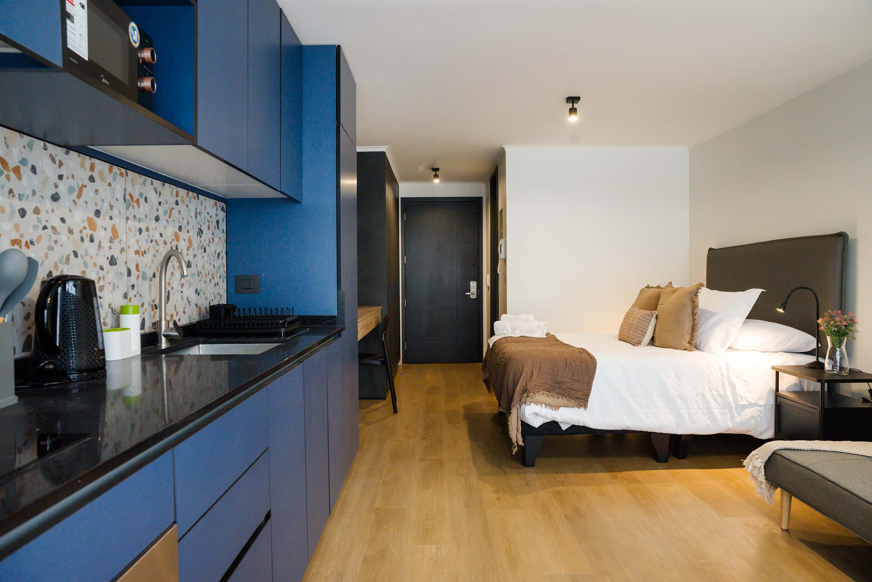 Modern studio with stylish kitchen and cozy sleeping area, perfect for a city escape.