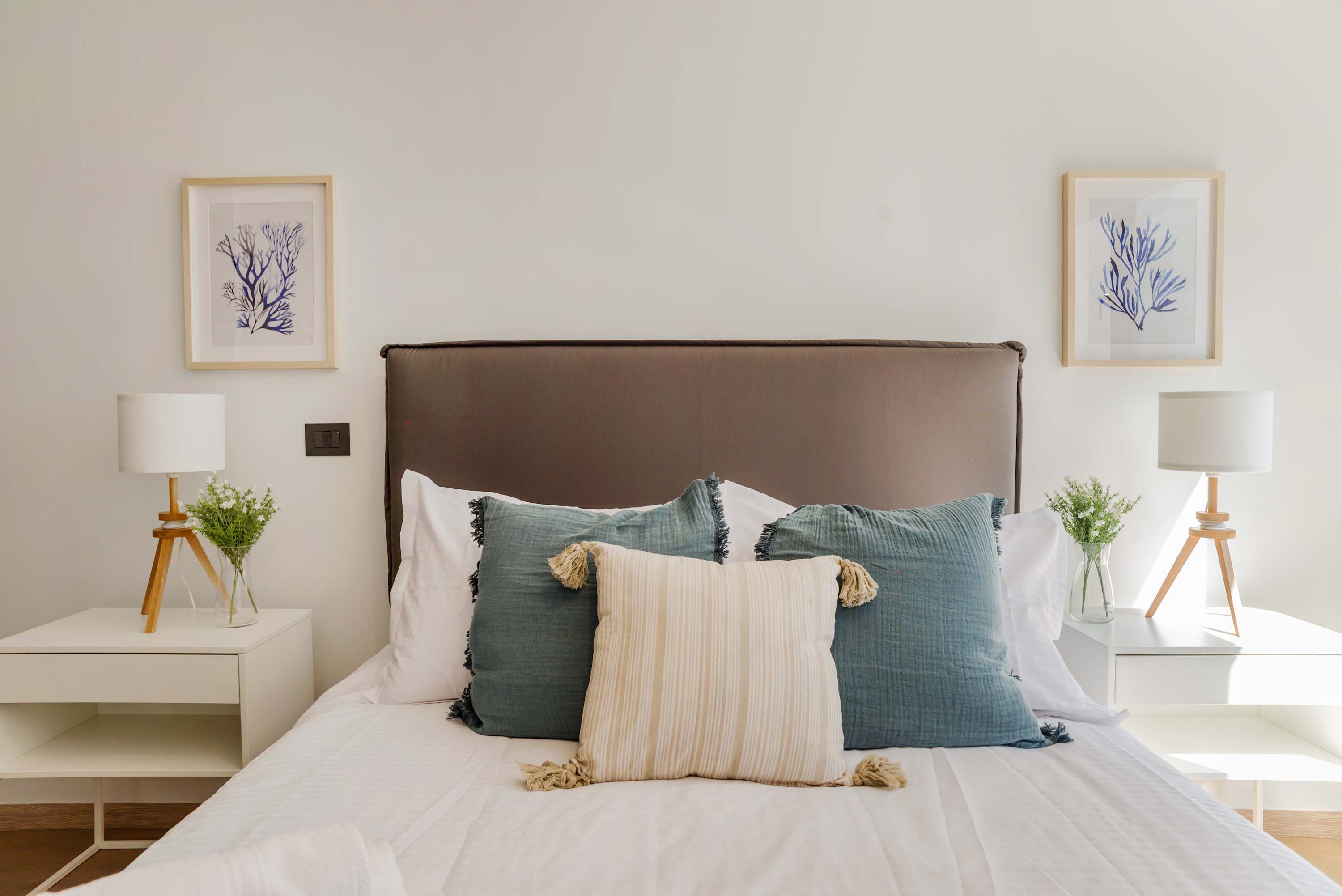 Enjoy a serene retreat in this stylish bedroom with plush pillows, elegant decor, and abundant natural light.