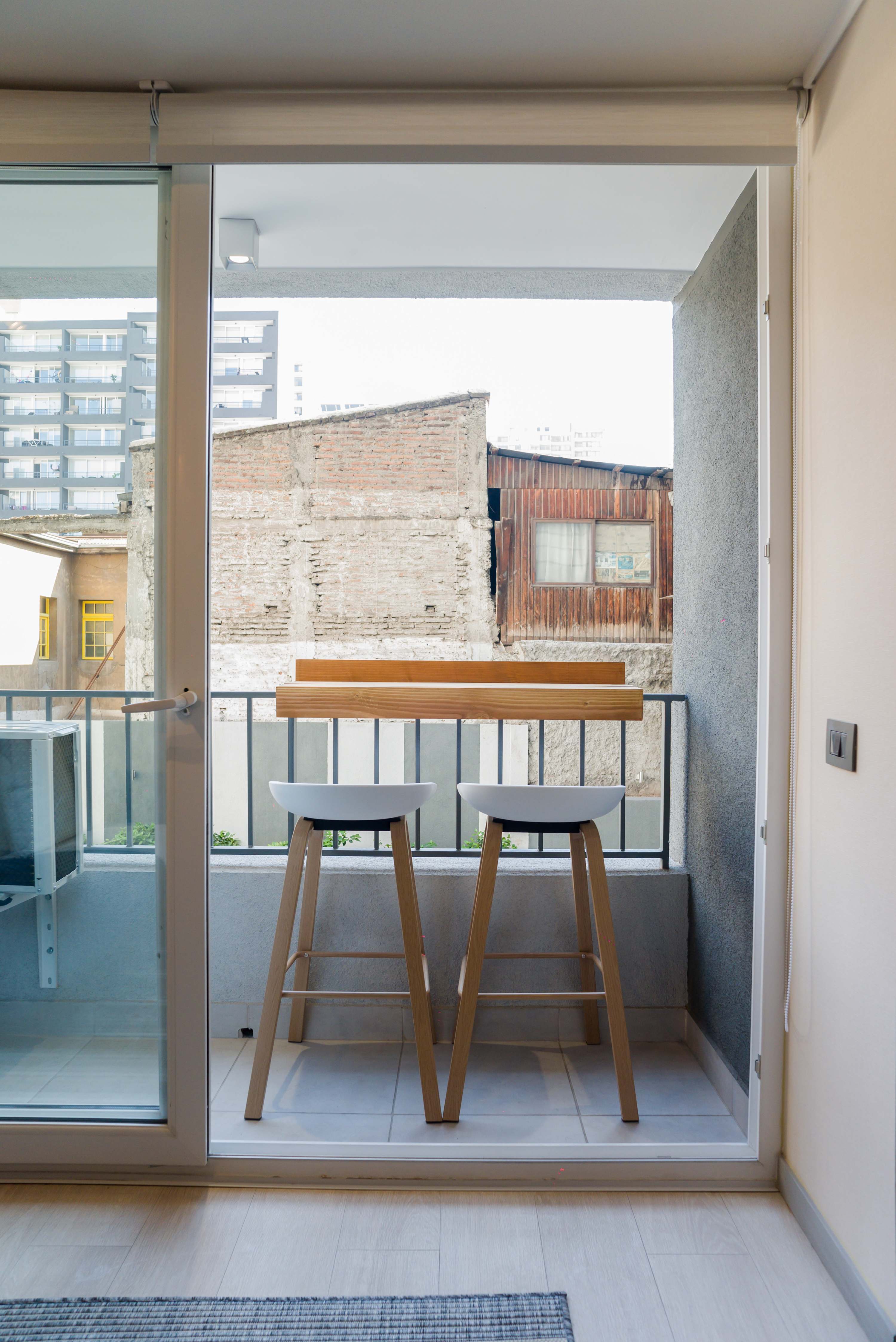 Cozy private balcony with seating, perfect for enjoying a morning coffee with an urban view.