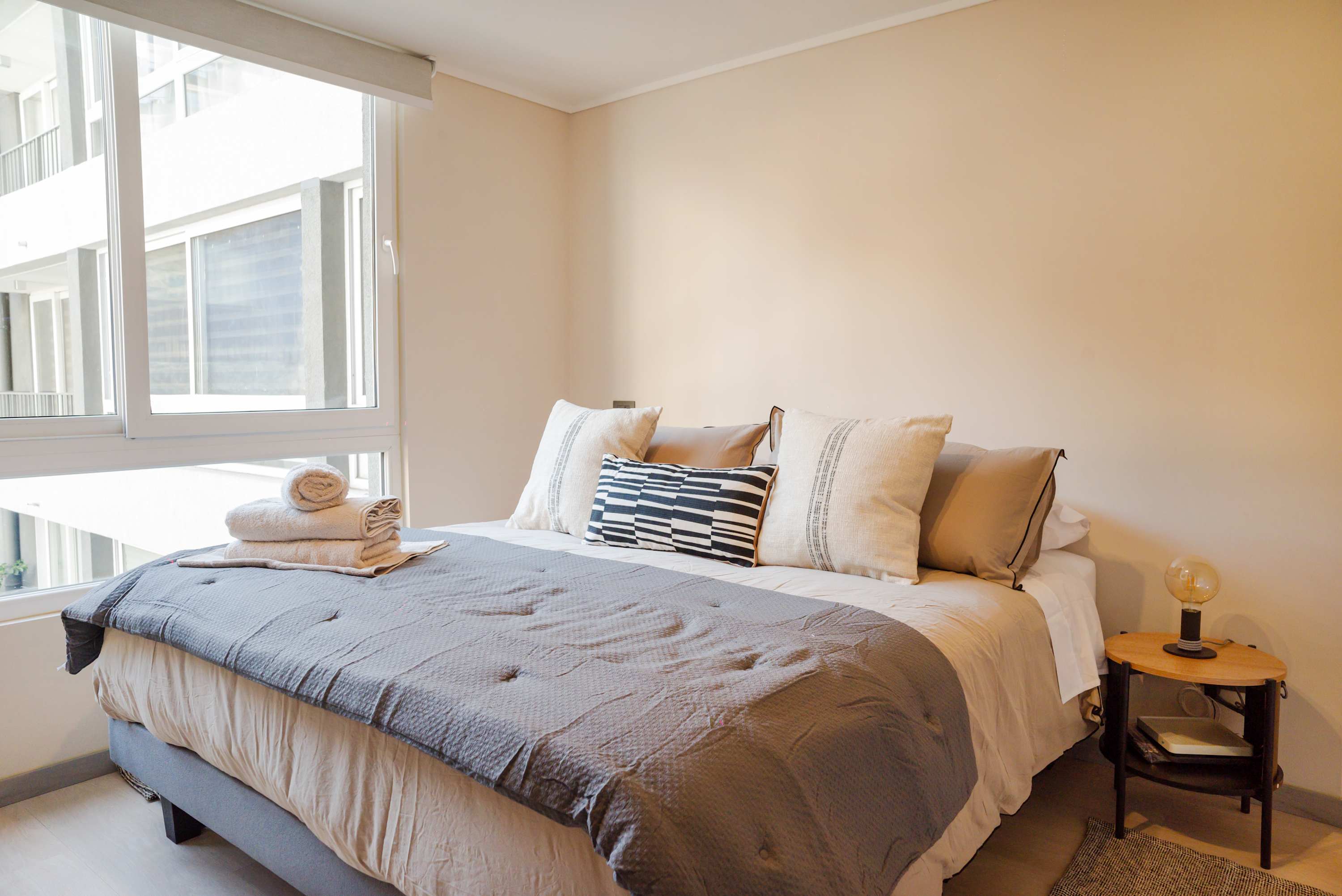 Relax in this cozy bedroom with plush bedding and ample natural light, perfect for a restful stay.
