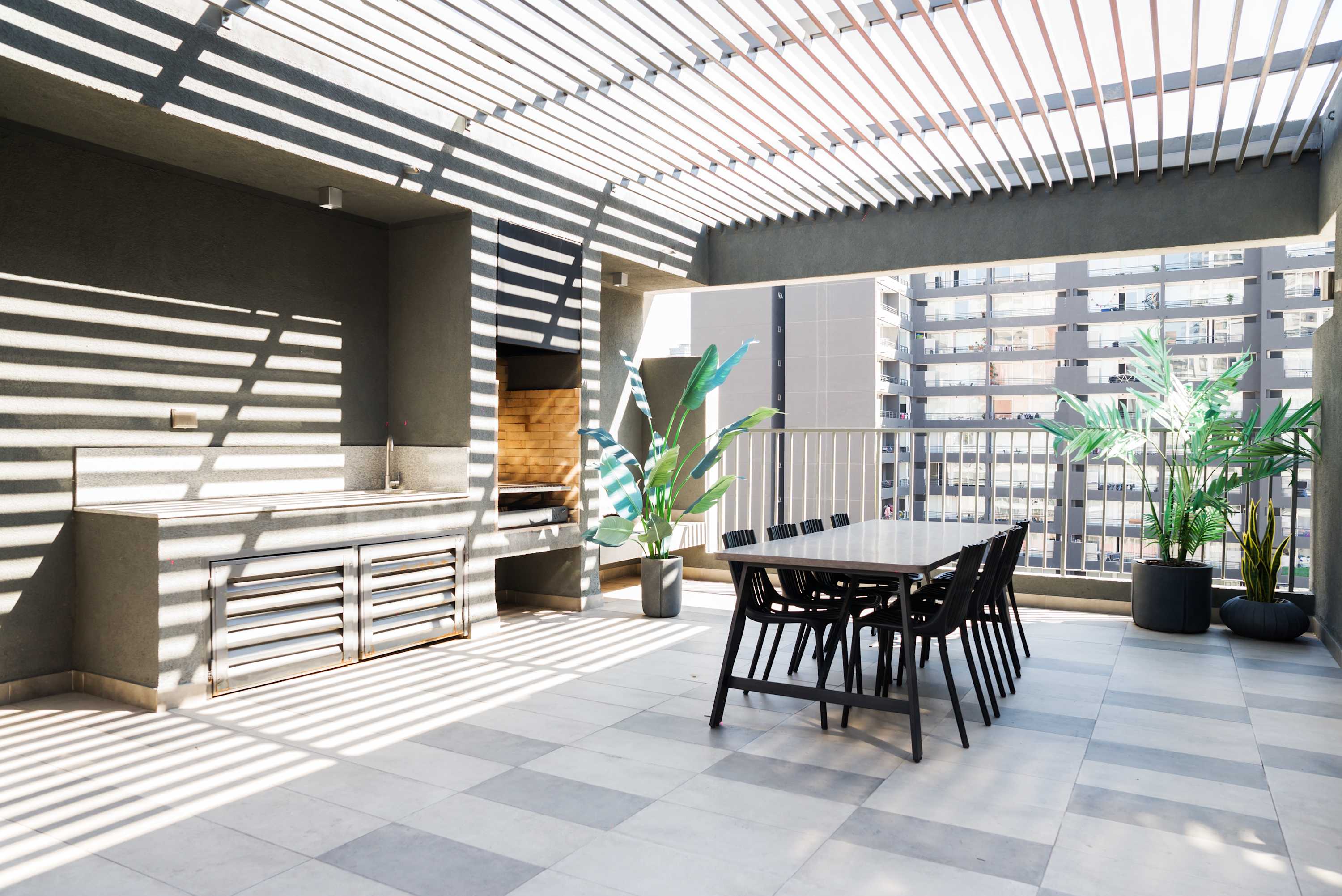 Enjoy a chic outdoor dining experience with a grill and cityscape views, perfect for gatherings. (Common Area)