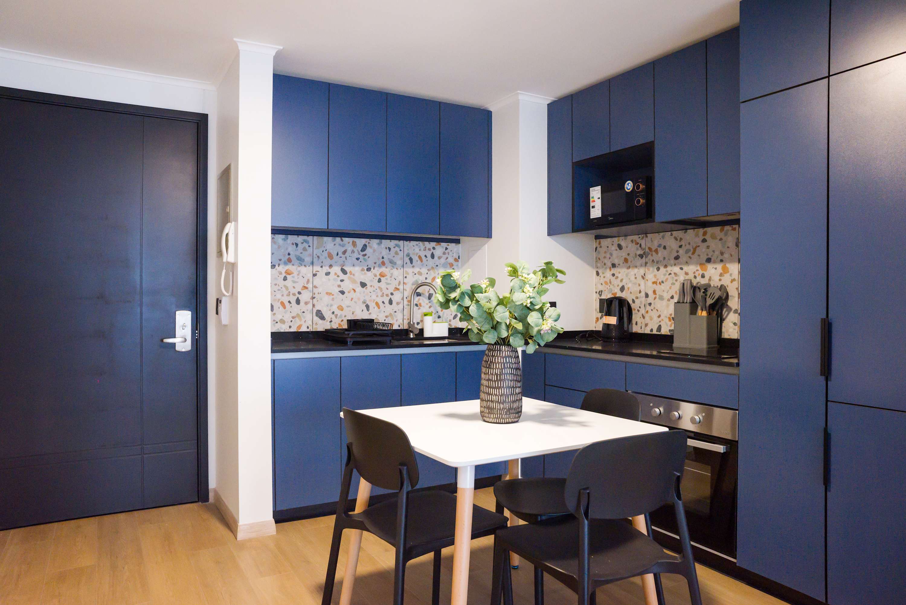 Stylish kitchen with blue cabinetry and terrazzo details, perfect for cozy meals and gatherings.