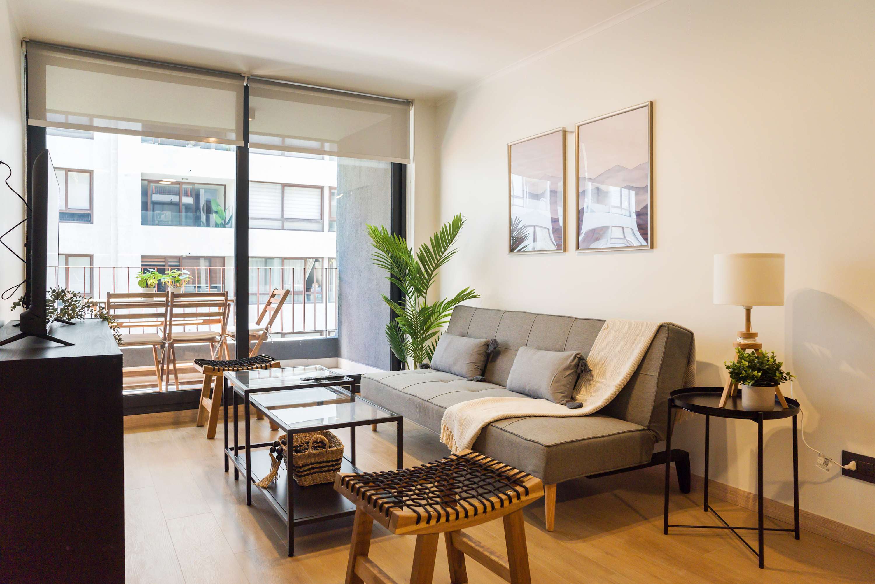 Relax in a stylish living area with chic decor and a cozy balcony view, perfect for unwinding.