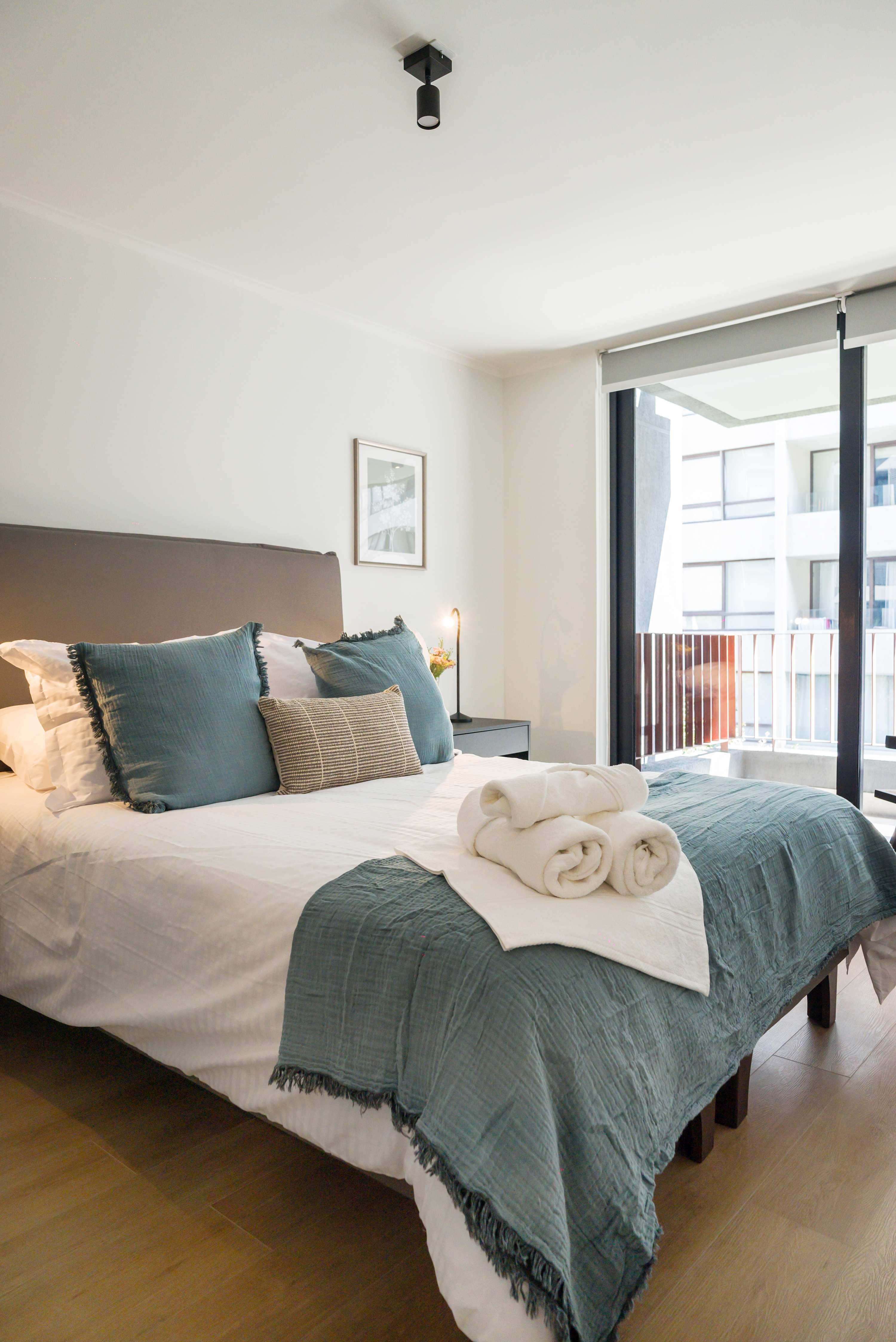 Relax in this cozy bedroom with plush bedding, natural light, and city views, perfect for unwinding after a day of exploring.