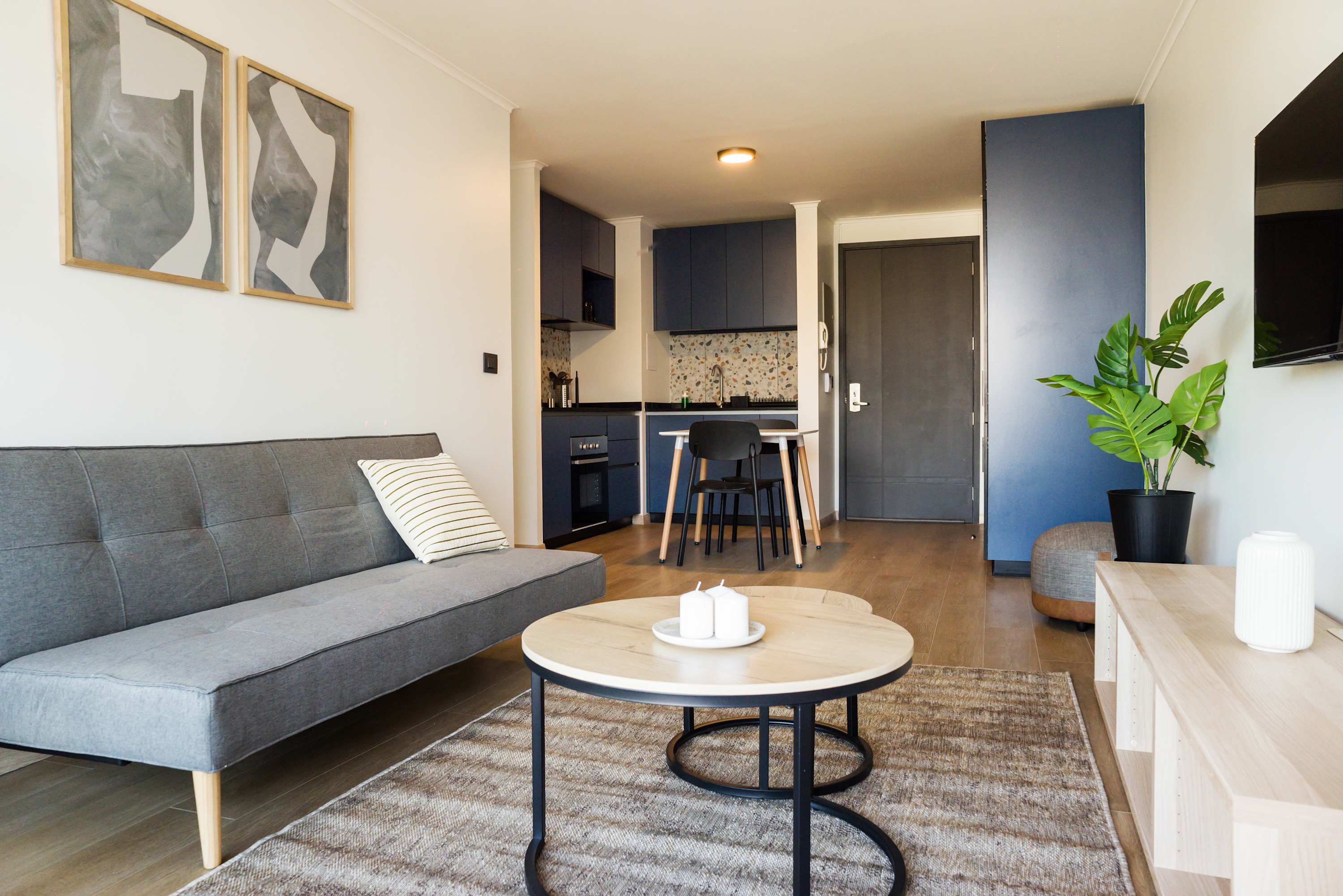 Modern living area with sleek decor and a compact kitchen, ideal for a cozy stay in the heart of the city.