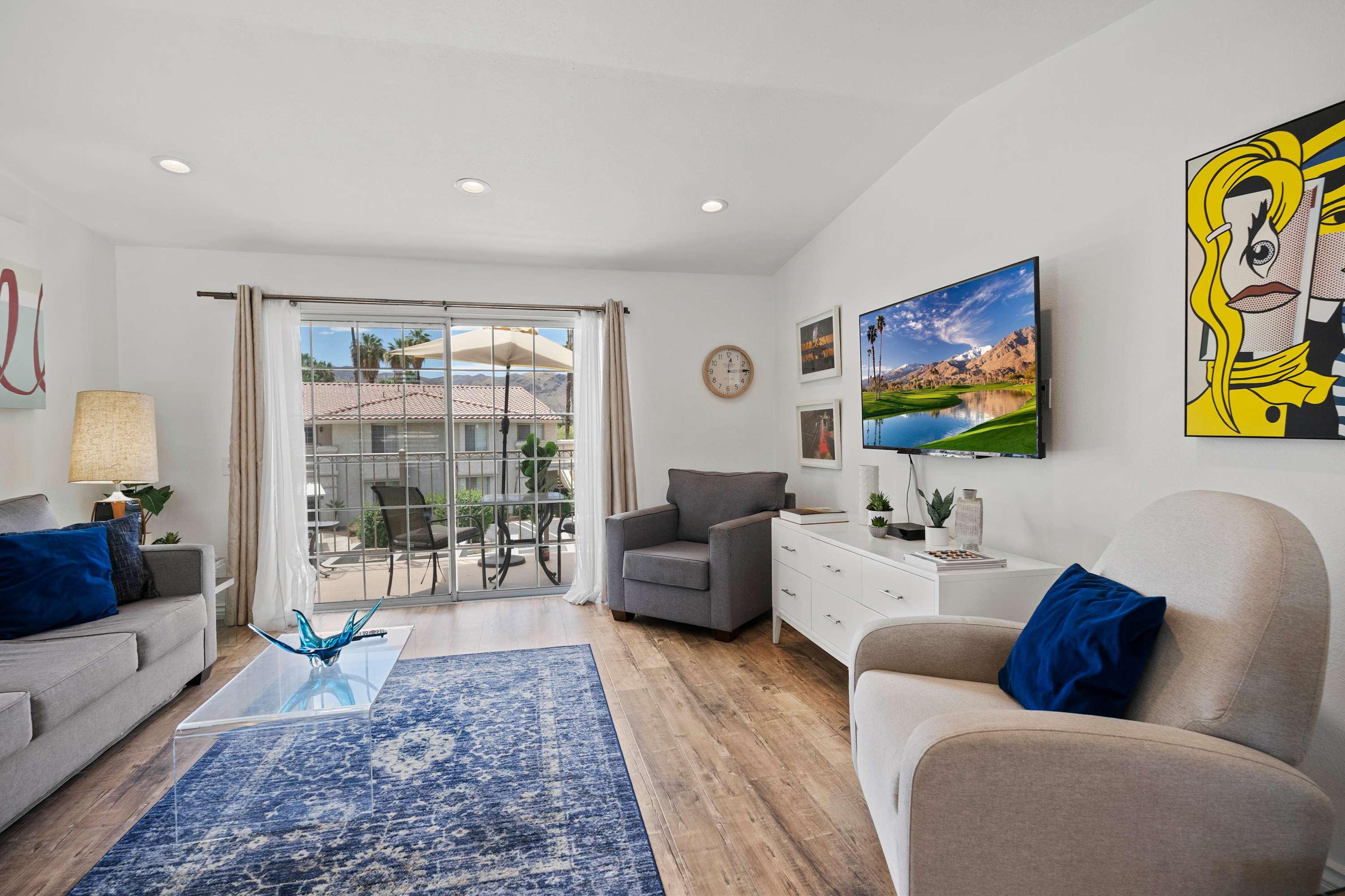Bright, open living room with plenty of seating, smart TV & balcony access 