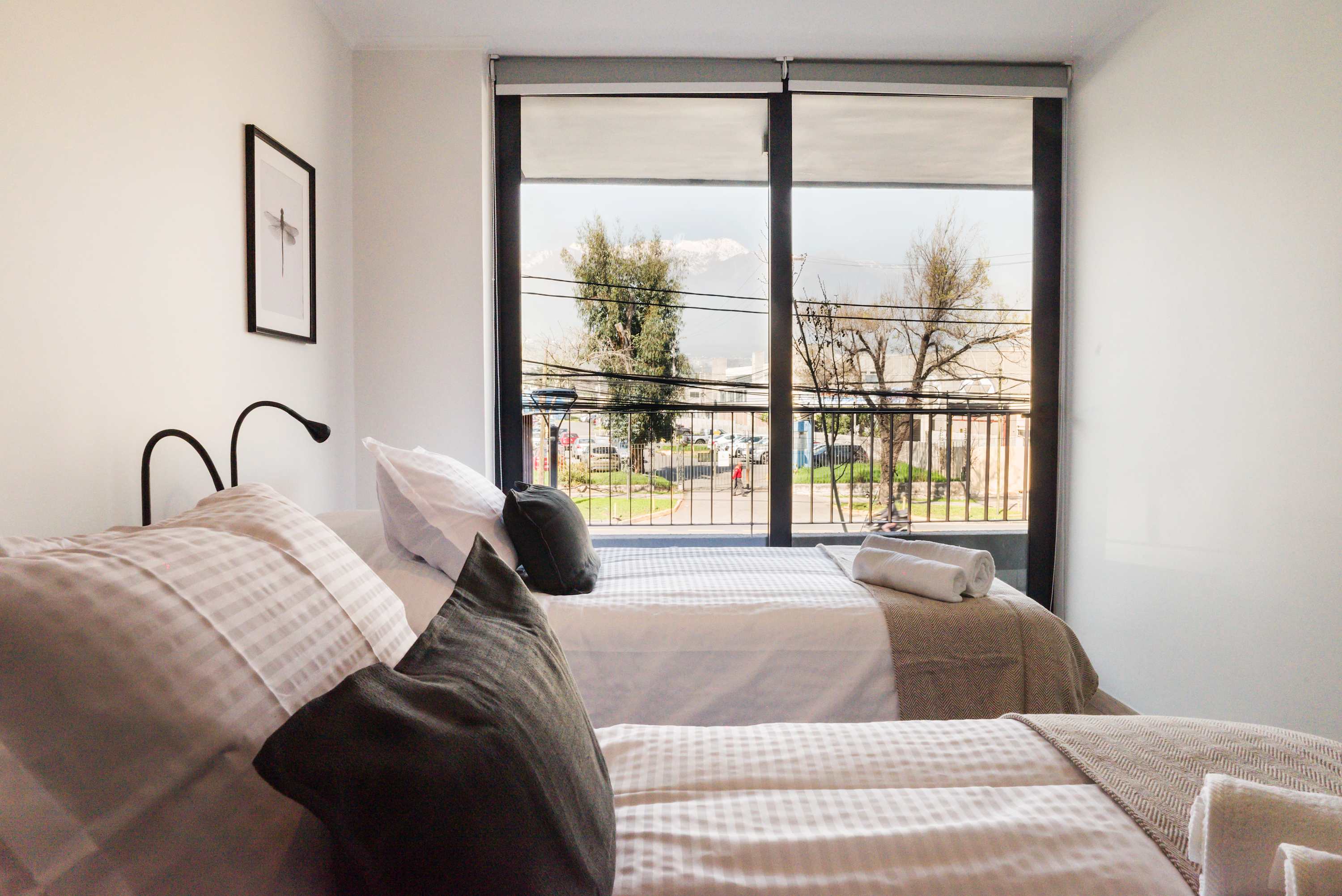 Cozy bedroom with twin beds and stunning mountain views, perfect for a relaxing stay in Chile.