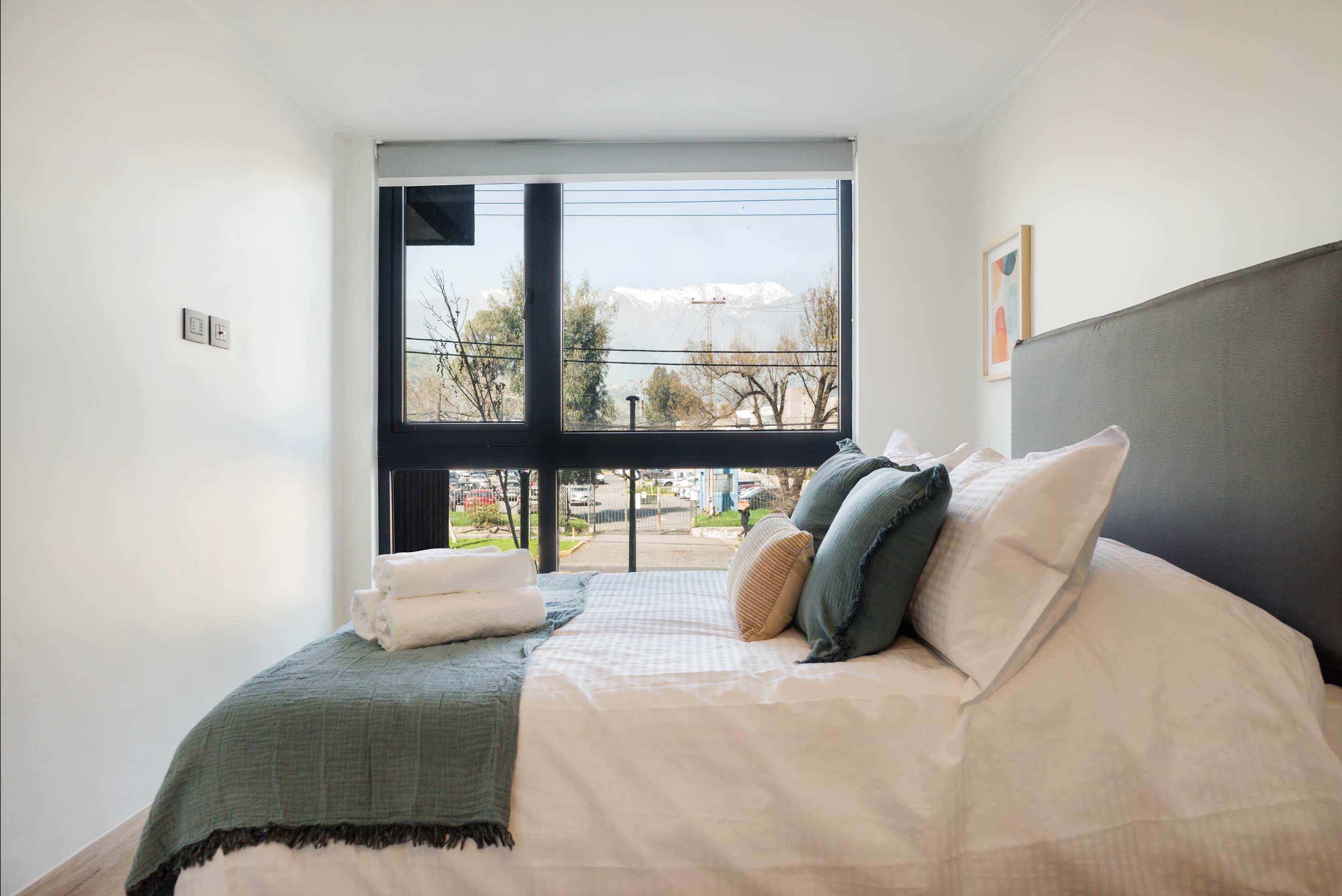 Unwind in this bright bedroom with stunning mountain views, perfect for relaxation after exploring Chile.