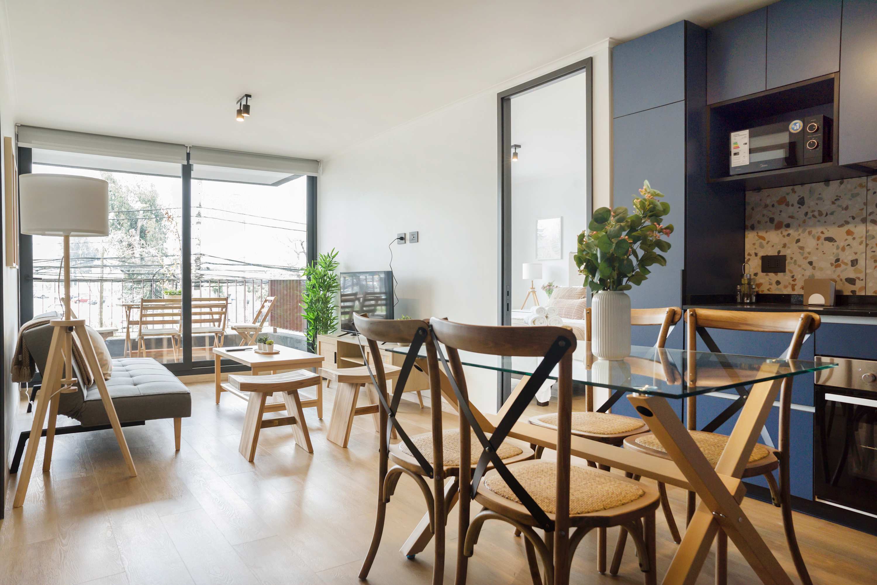 Bright living area with balcony access, modern decor, and a cozy dining space for relaxation.