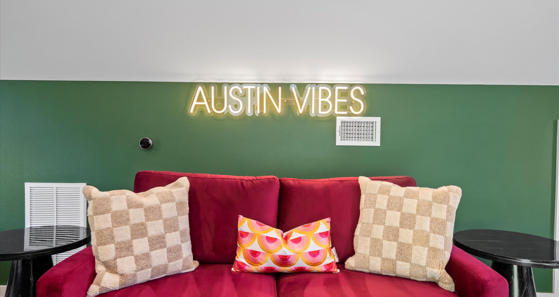 Vibrant bedroom featuring four single beds, styled with bold tones of olive green, burnt orange, and rich burgundy furnishings