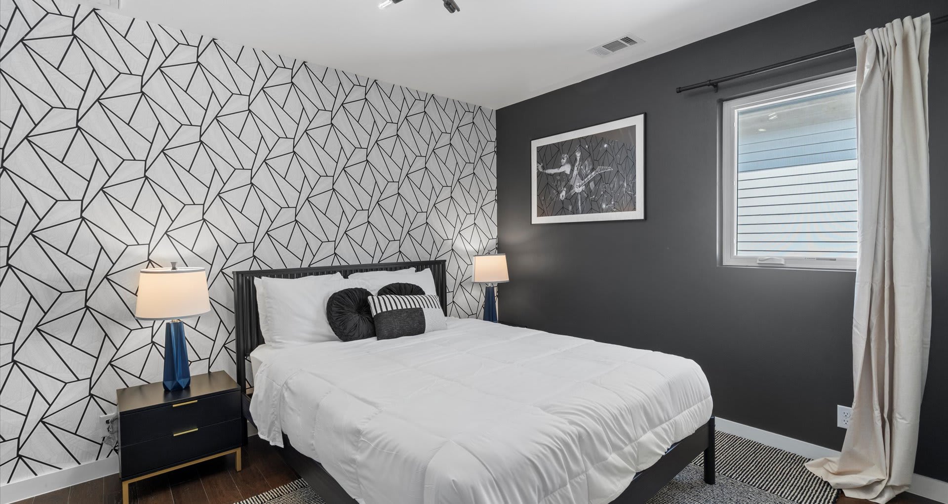 Chic queen bedroom designed in calming grey and white tones, accented with modern abstract wallpaper for a stylish yet relaxing retreat.