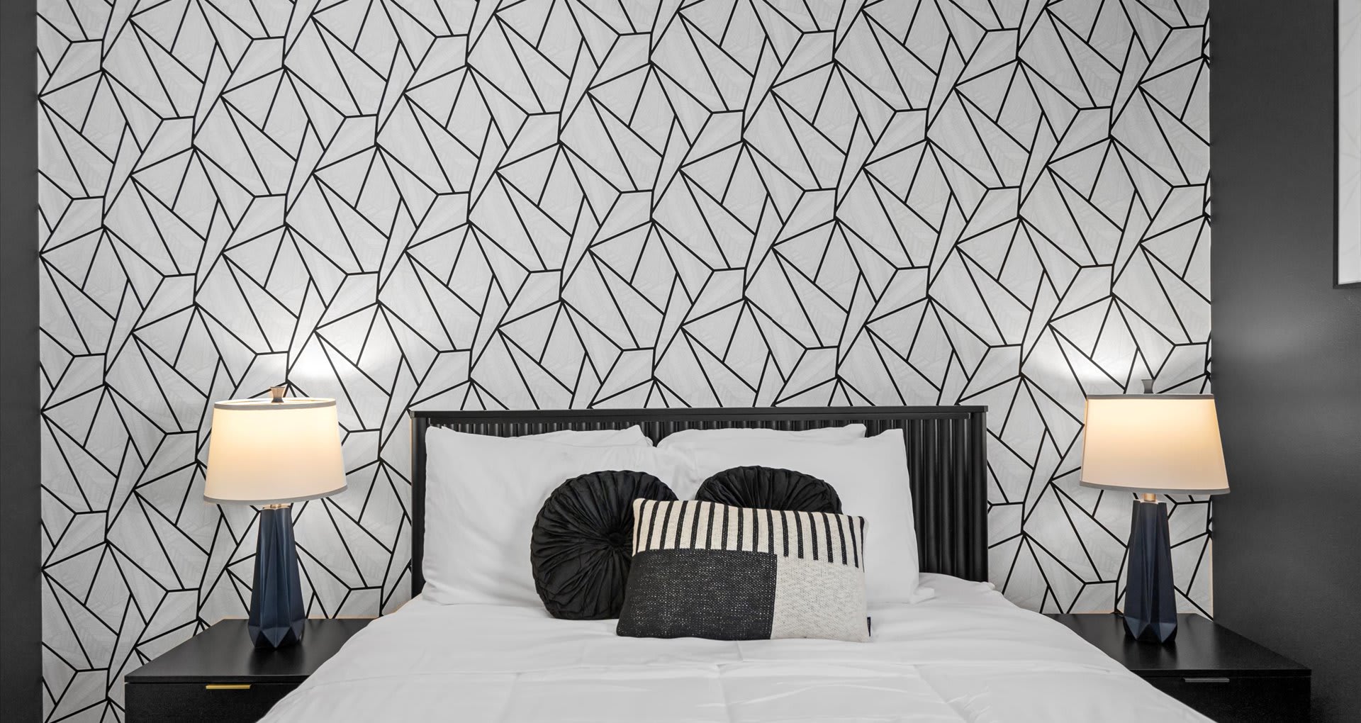 Chic queen bedroom designed in calming grey and white tones, accented with modern abstract wallpaper for a stylish yet relaxing retreat.