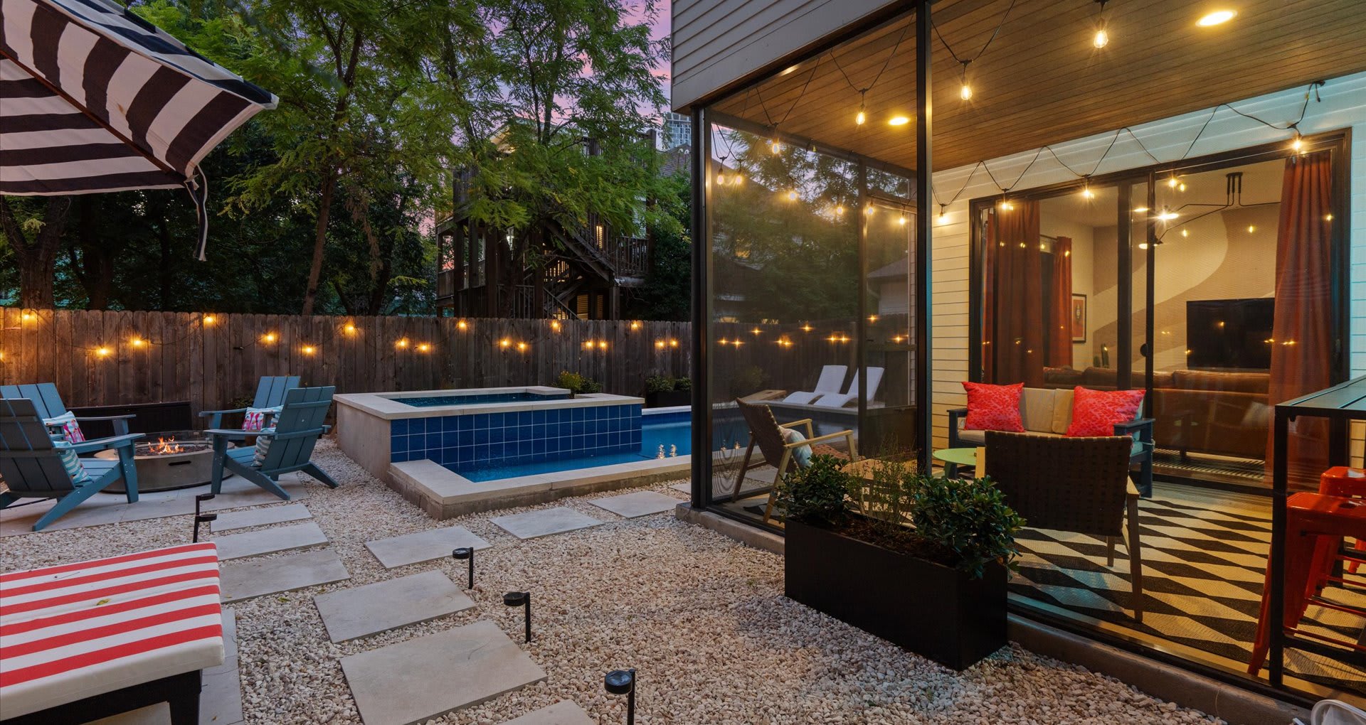 Private outdoor pool with striped sun loungers and umbrellas