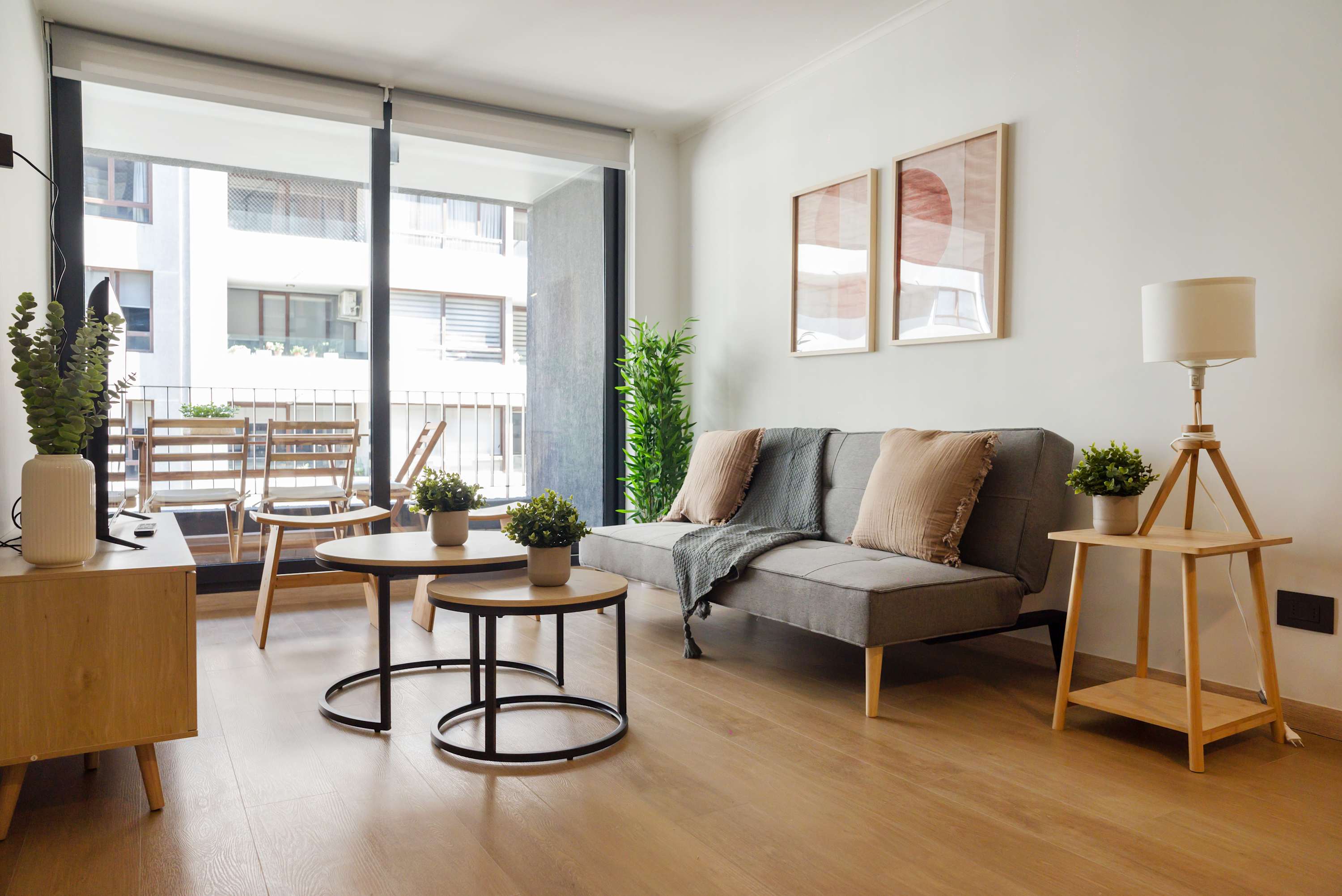 Bright and modern living area with a cozy sofa and balcony access, perfect for city relaxation.