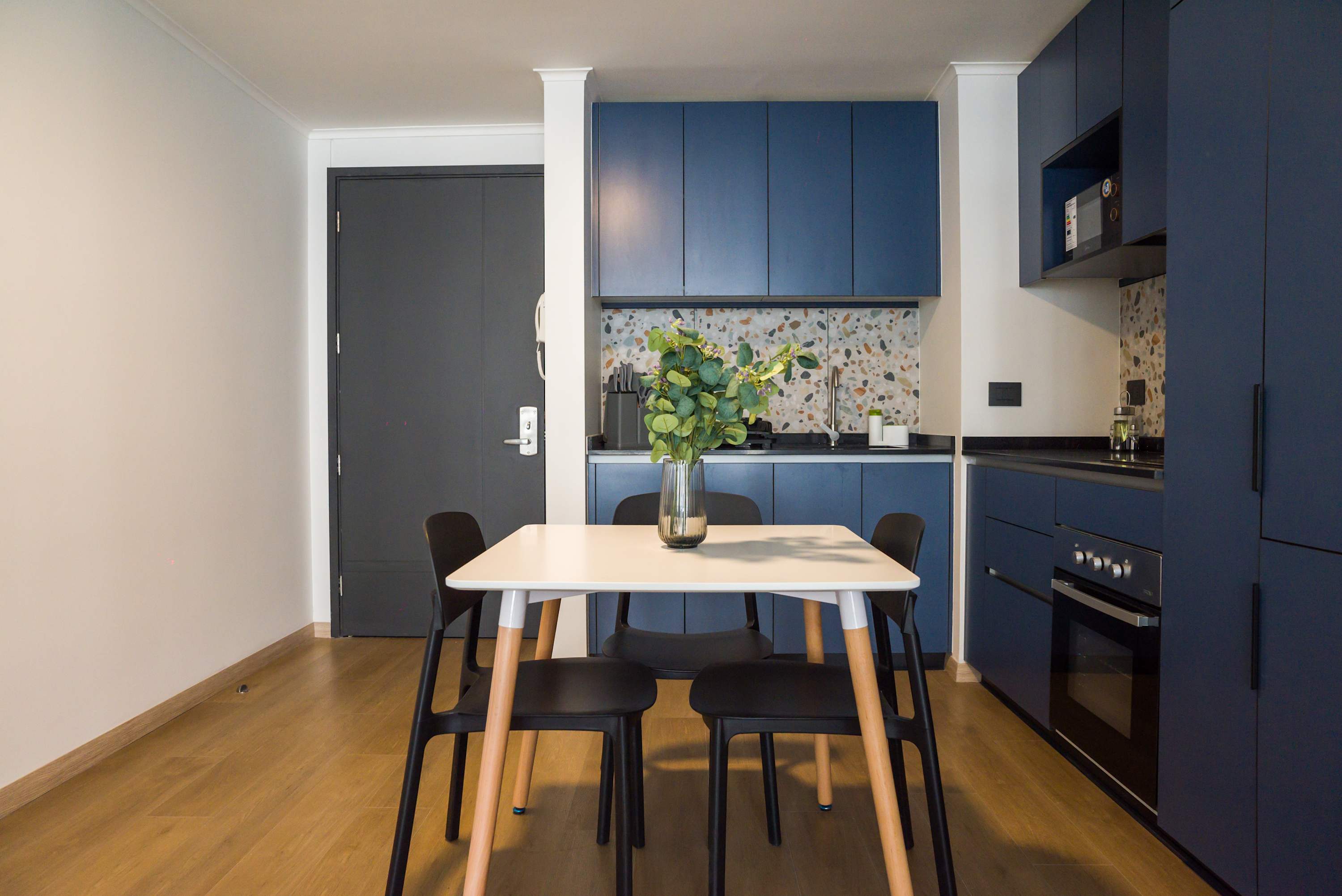 Chic kitchen with blue cabinets and terrazzo accents, ideal for cozy meals and culinary creativity.