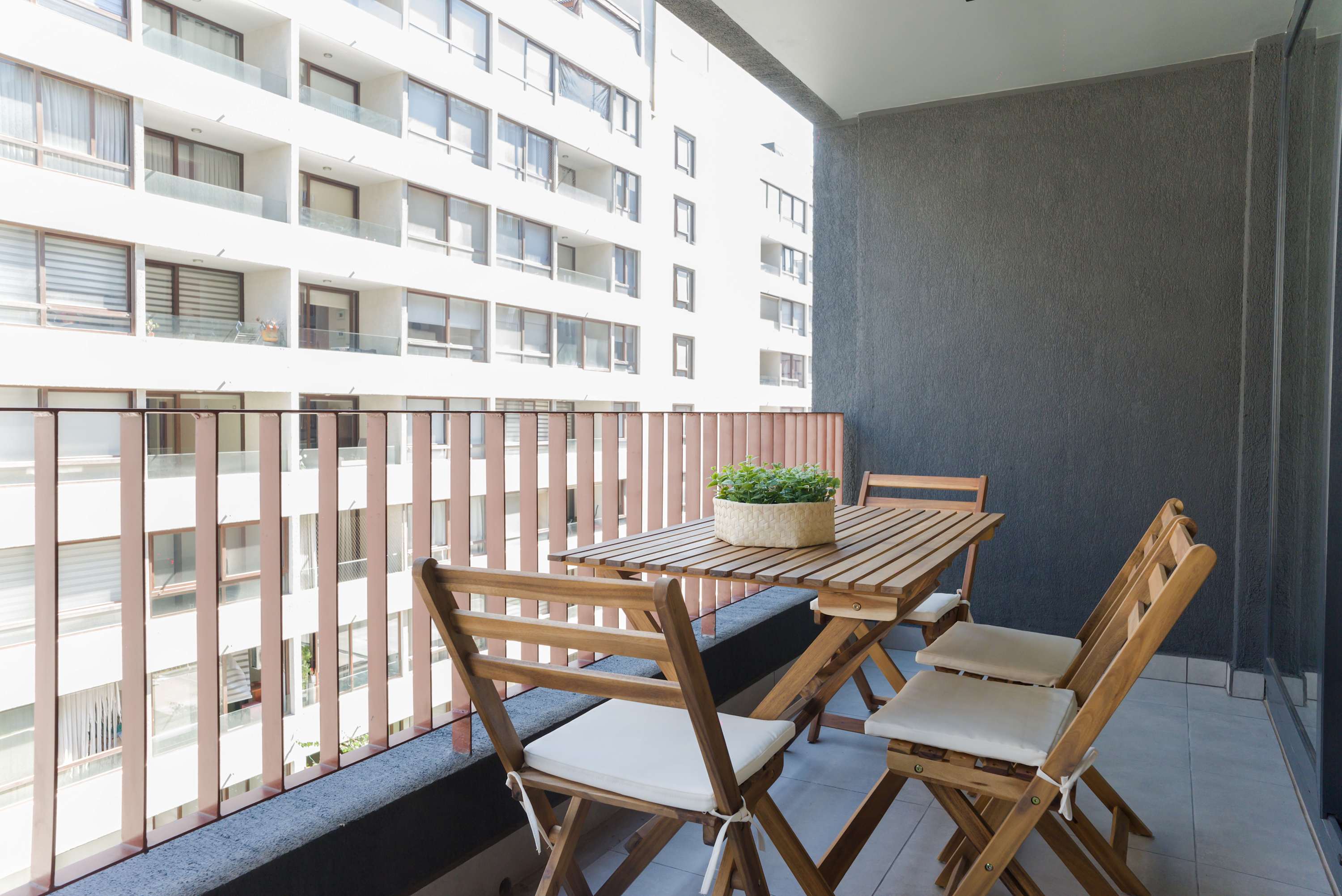 Enjoy your morning coffee on this private balcony with a charming urban view and cozy seating area.