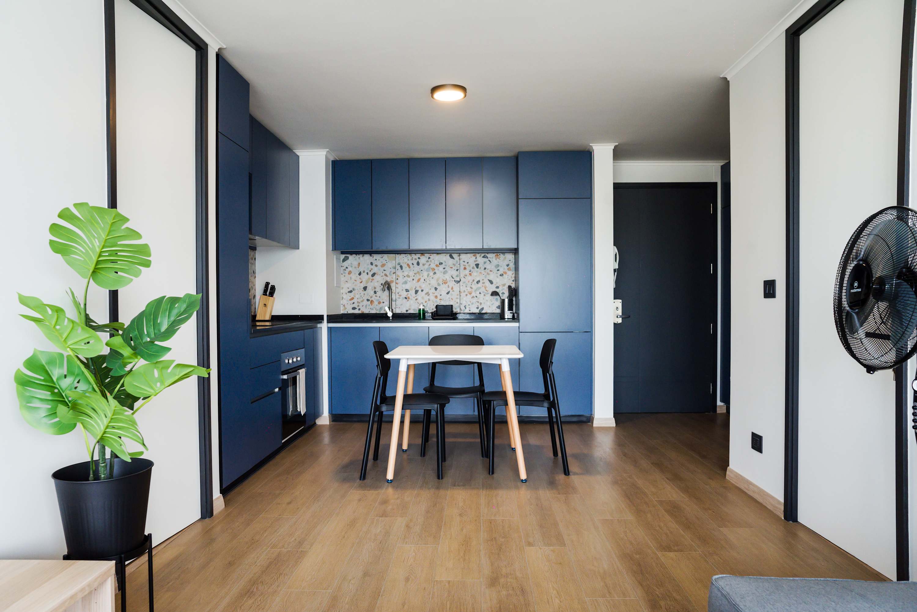 Stylish kitchen with blue cabinets and a cozy dining nook, ideal for intimate meals.