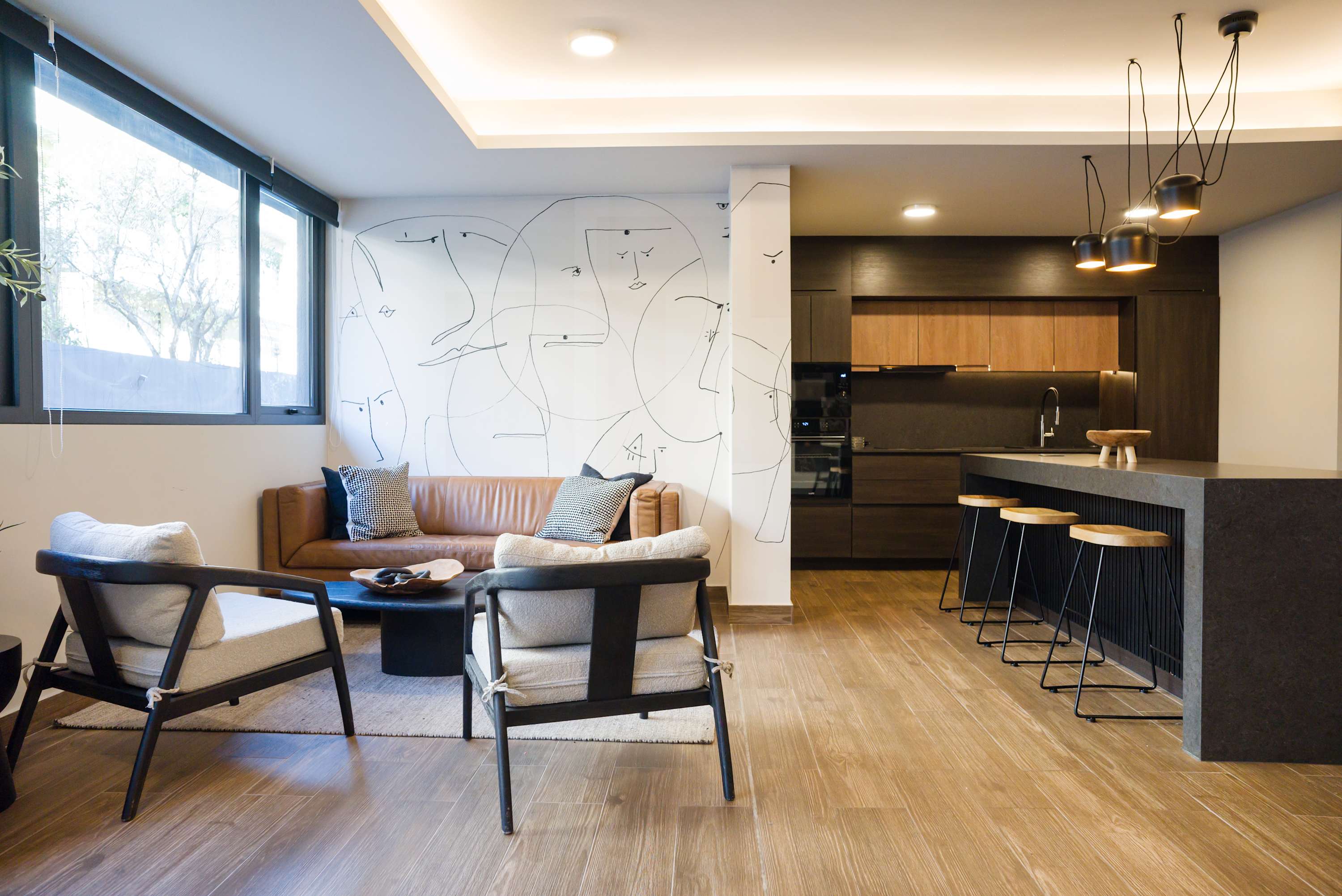 Stylish living area with modern decor and open kitchen, perfect for relaxation and entertaining.