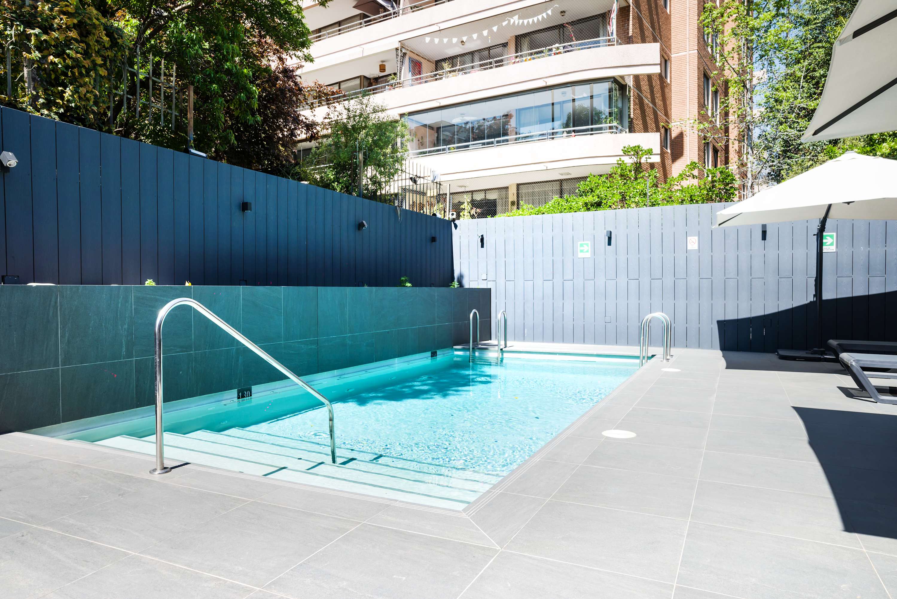 Relax by the modern poolside oasis, perfect for unwinding after a day of exploring the city.