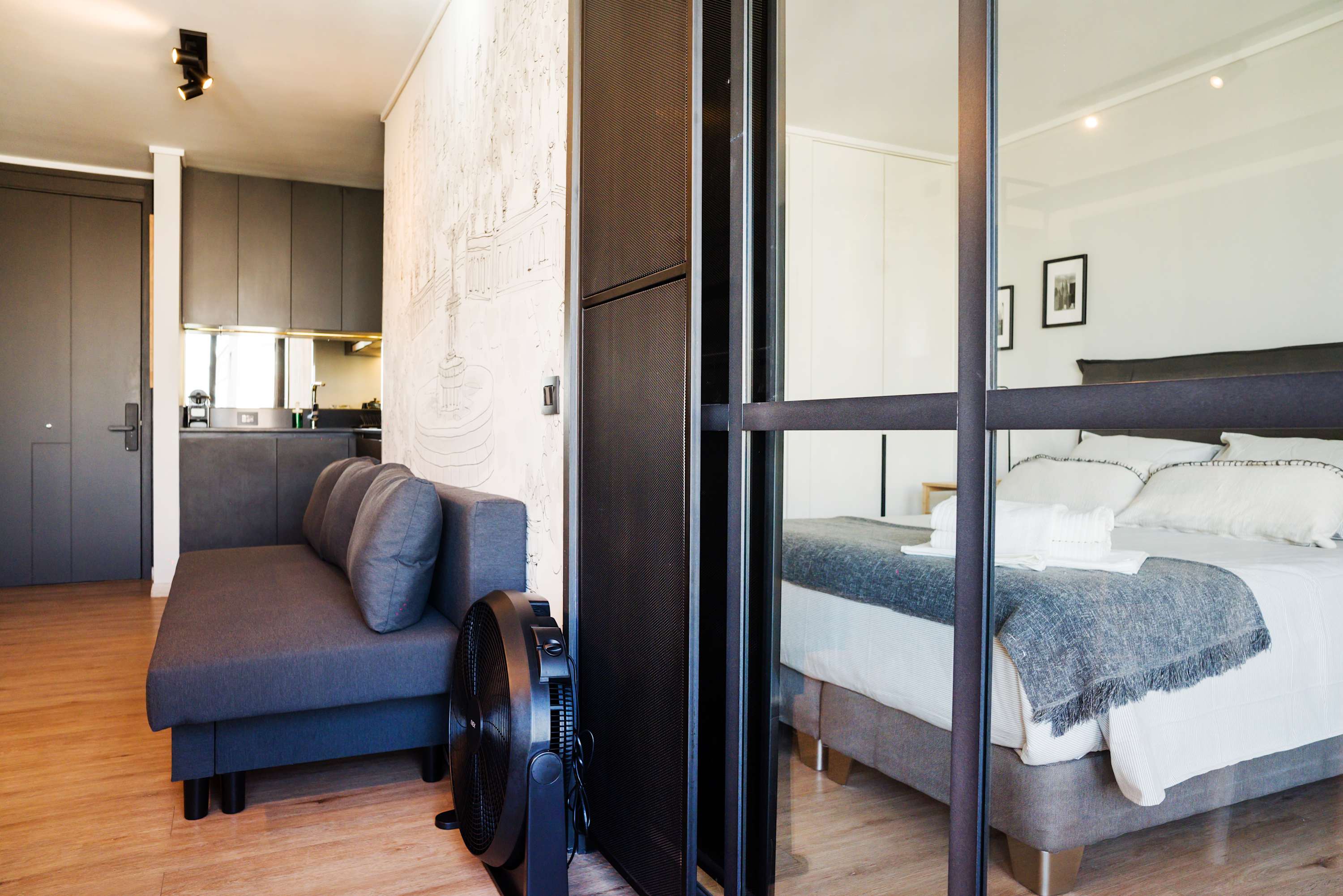 Cozy studio with modern design, featuring a stylish glass partition separating the living and sleeping areas.