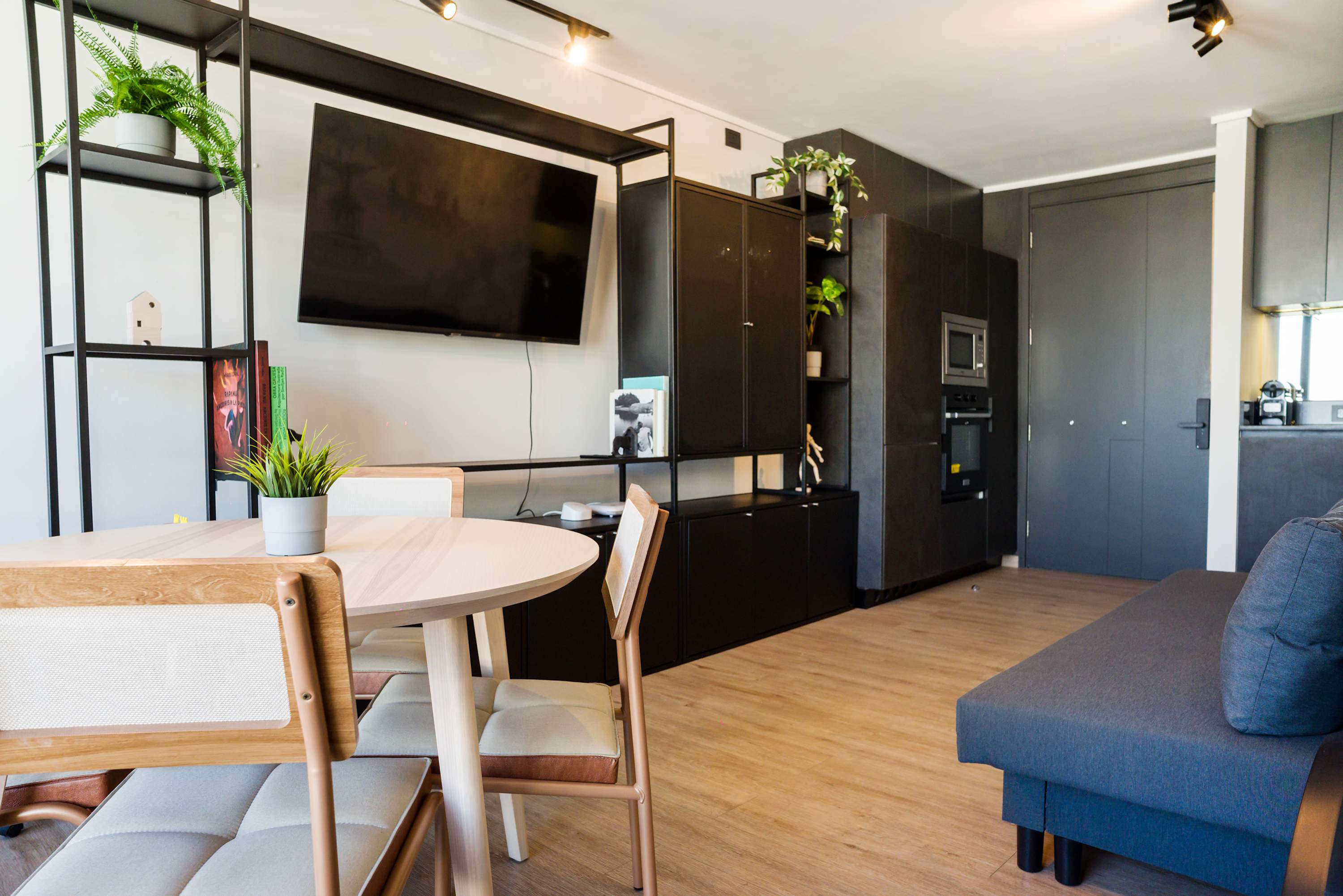 Stylish and modern living area with a cozy dining space and sleek entertainment setup, perfect for relaxation and dining.