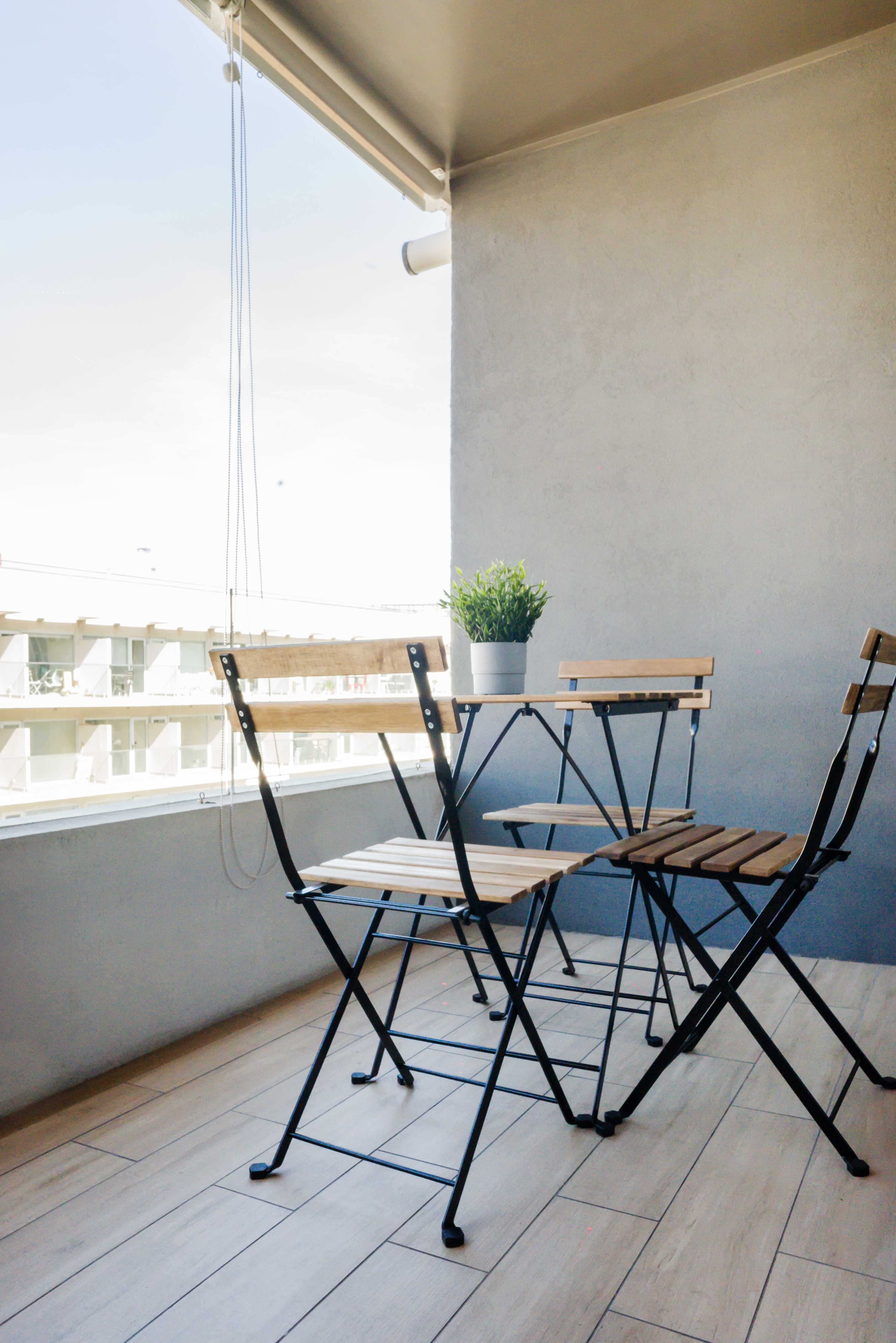Enjoy your morning coffee on this charming private balcony with seating for three and a refreshing view.
