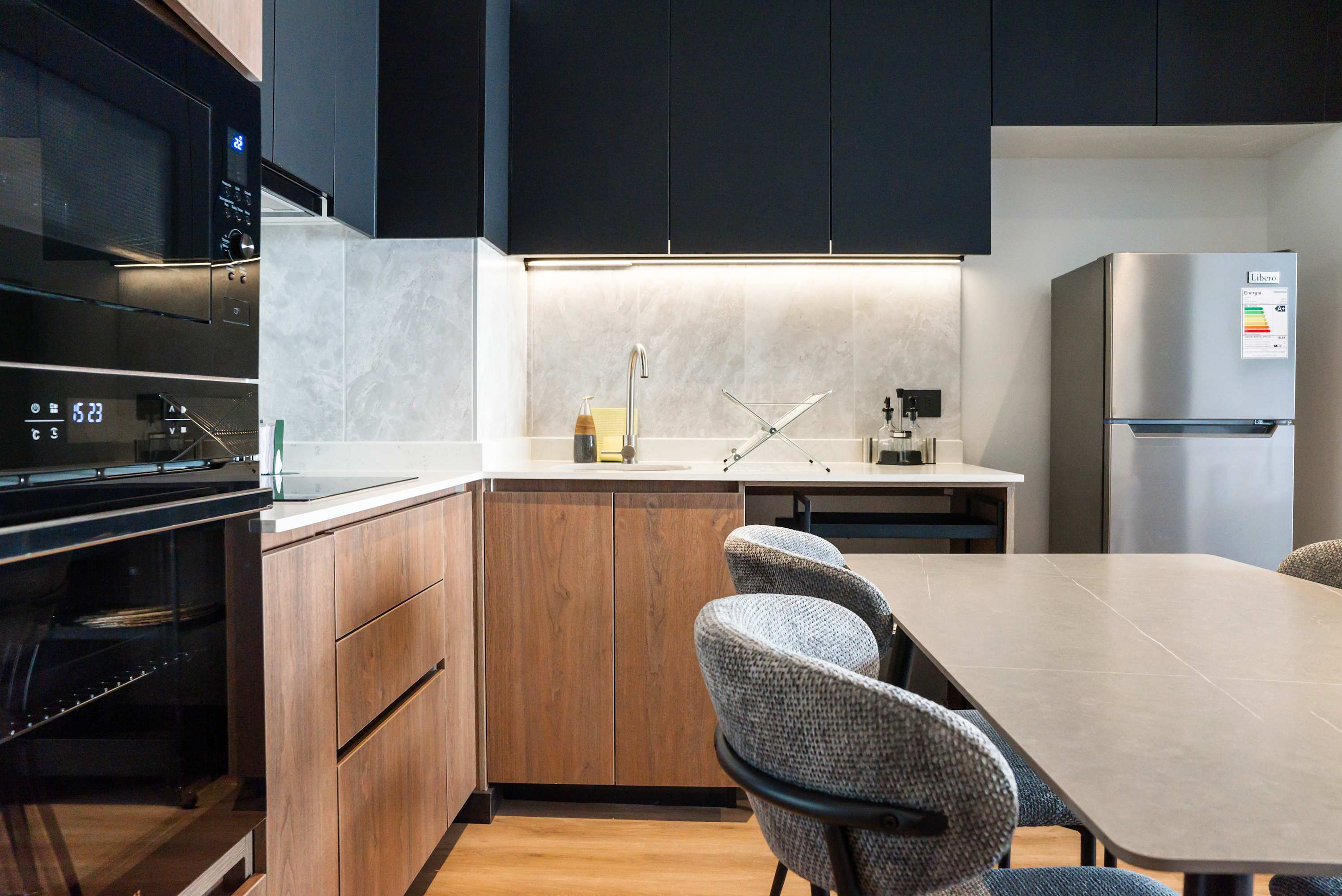 Modern kitchen with sleek appliances and ample seating, perfect for enjoying meals in comfort.