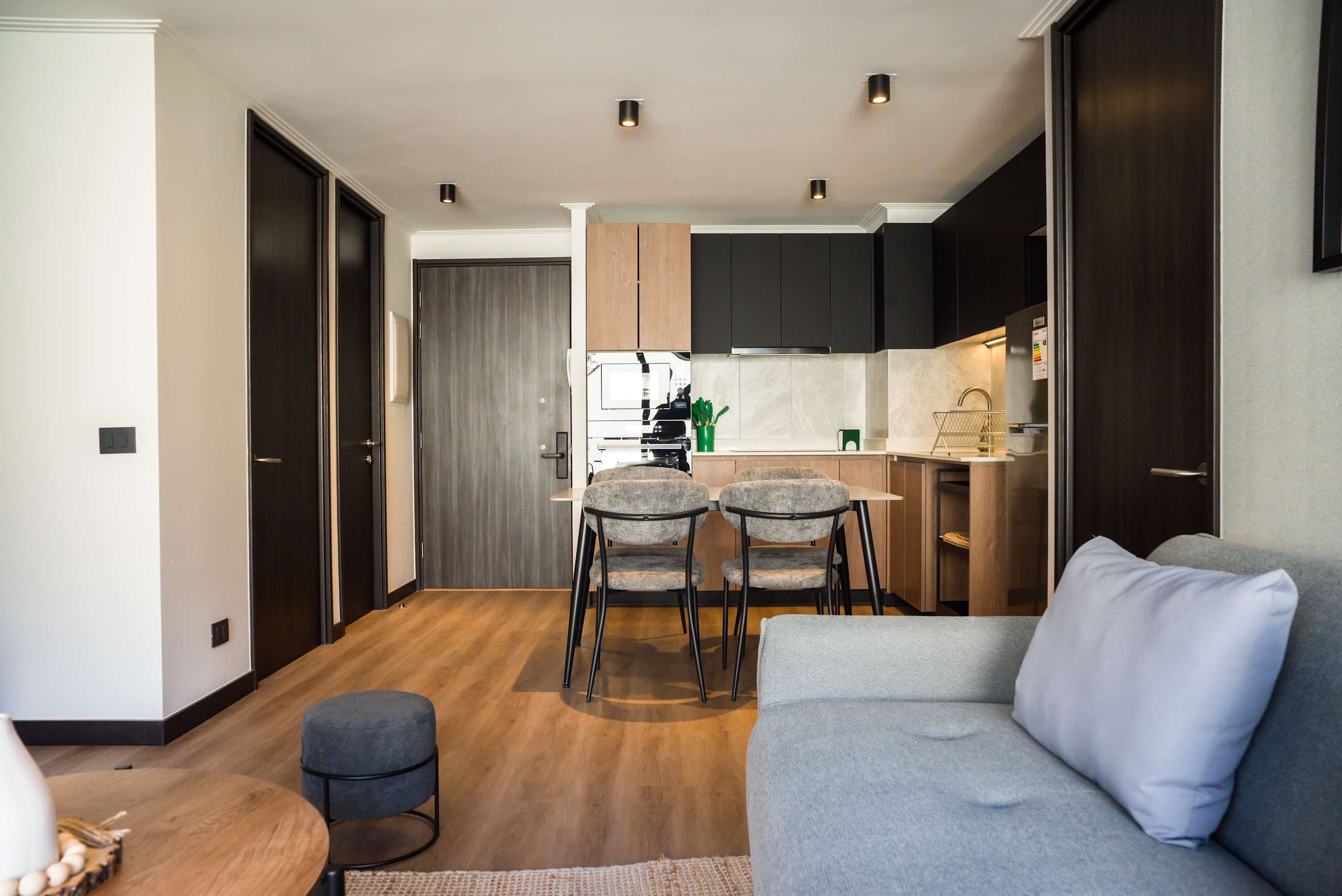 Modern living area with a cozy sofa, dining space, and sleek kitchen, ideal for relaxation and dining.